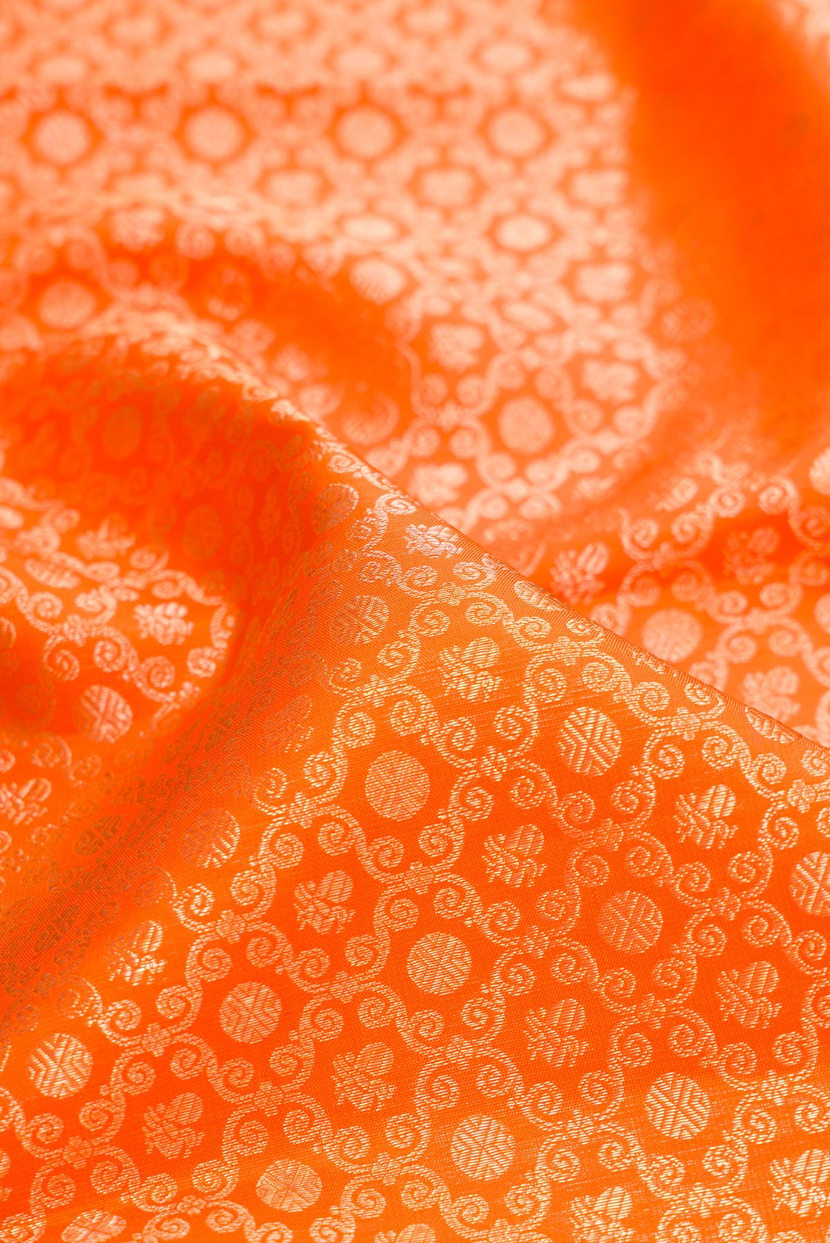 Close up of Pure Silk Orange Kanchipuram Saree with Zari Brocade on the body and Fancy Border.  displaying folds