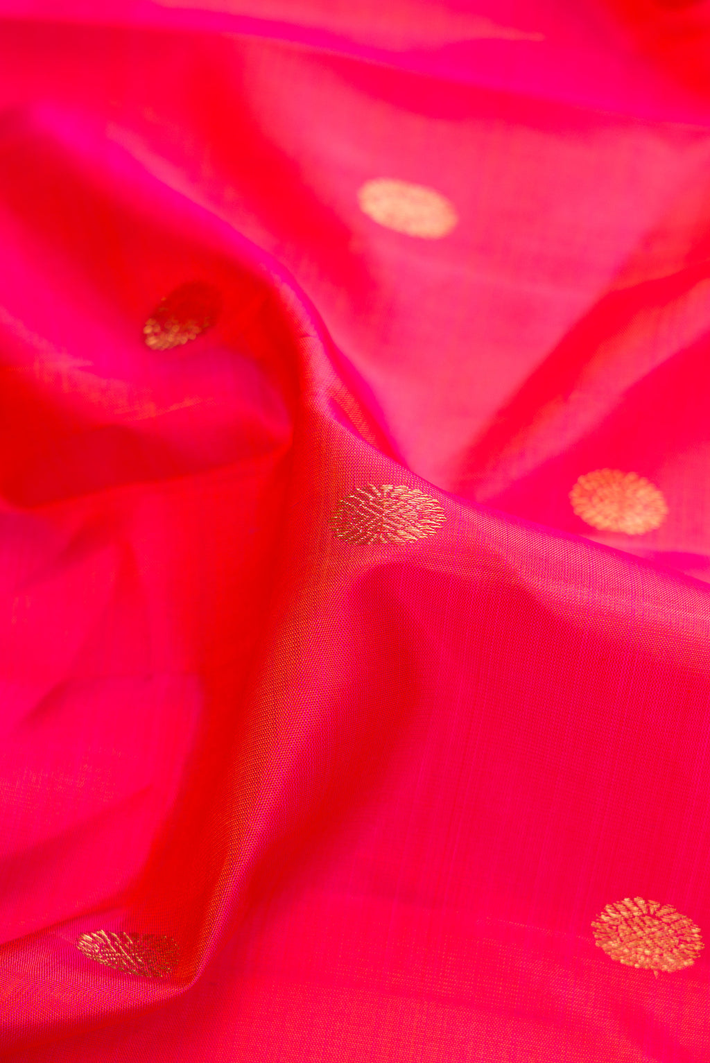 Close up of Pure Silk Coral Dual Tone Kanjivaram Saree with Zari Butta on the body and Zari Border.  displaying folds