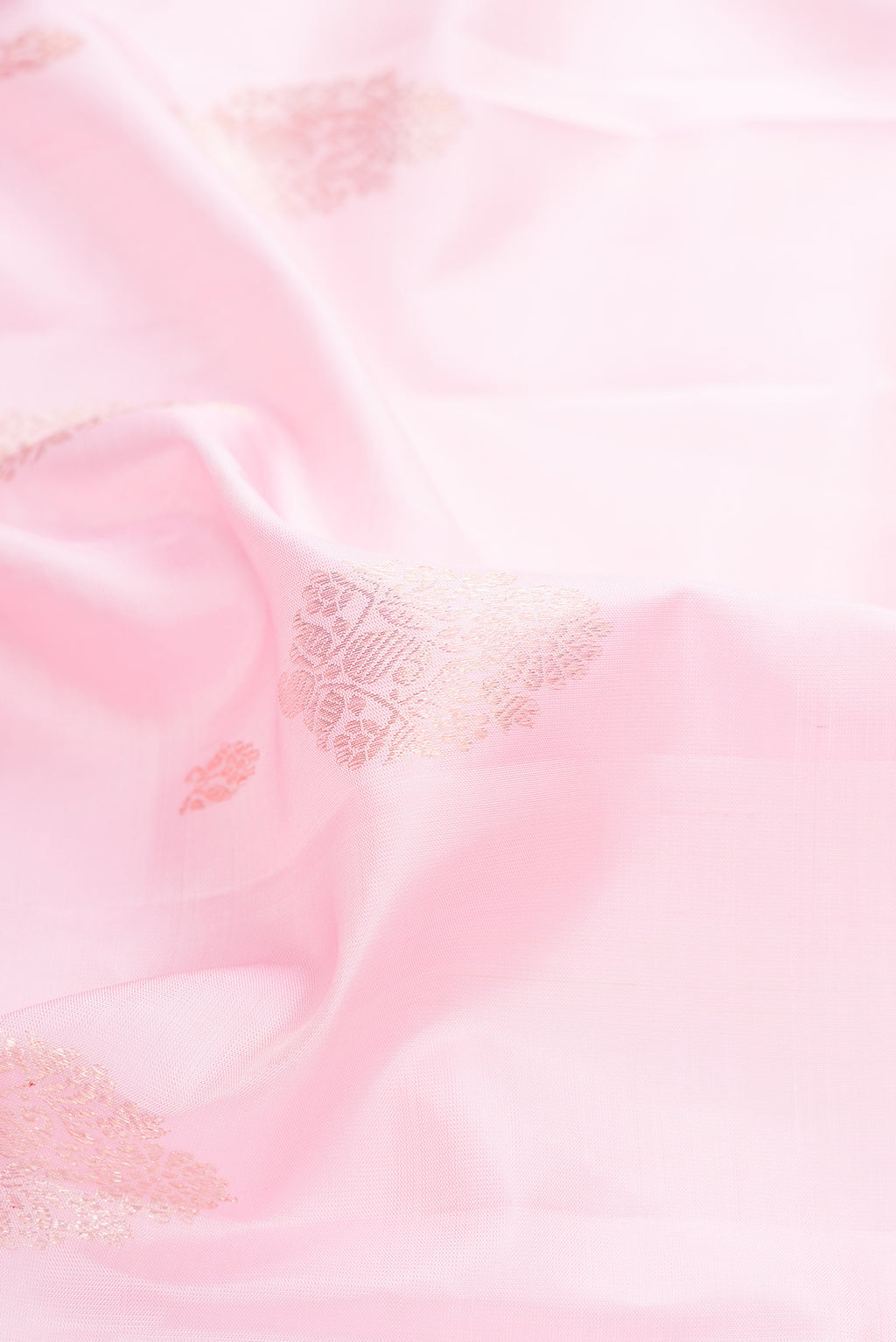 Close up of Pure Silk Rose pink Kanjivaram Saree with Zari Butta on the body and Zari Border.  displaying folds