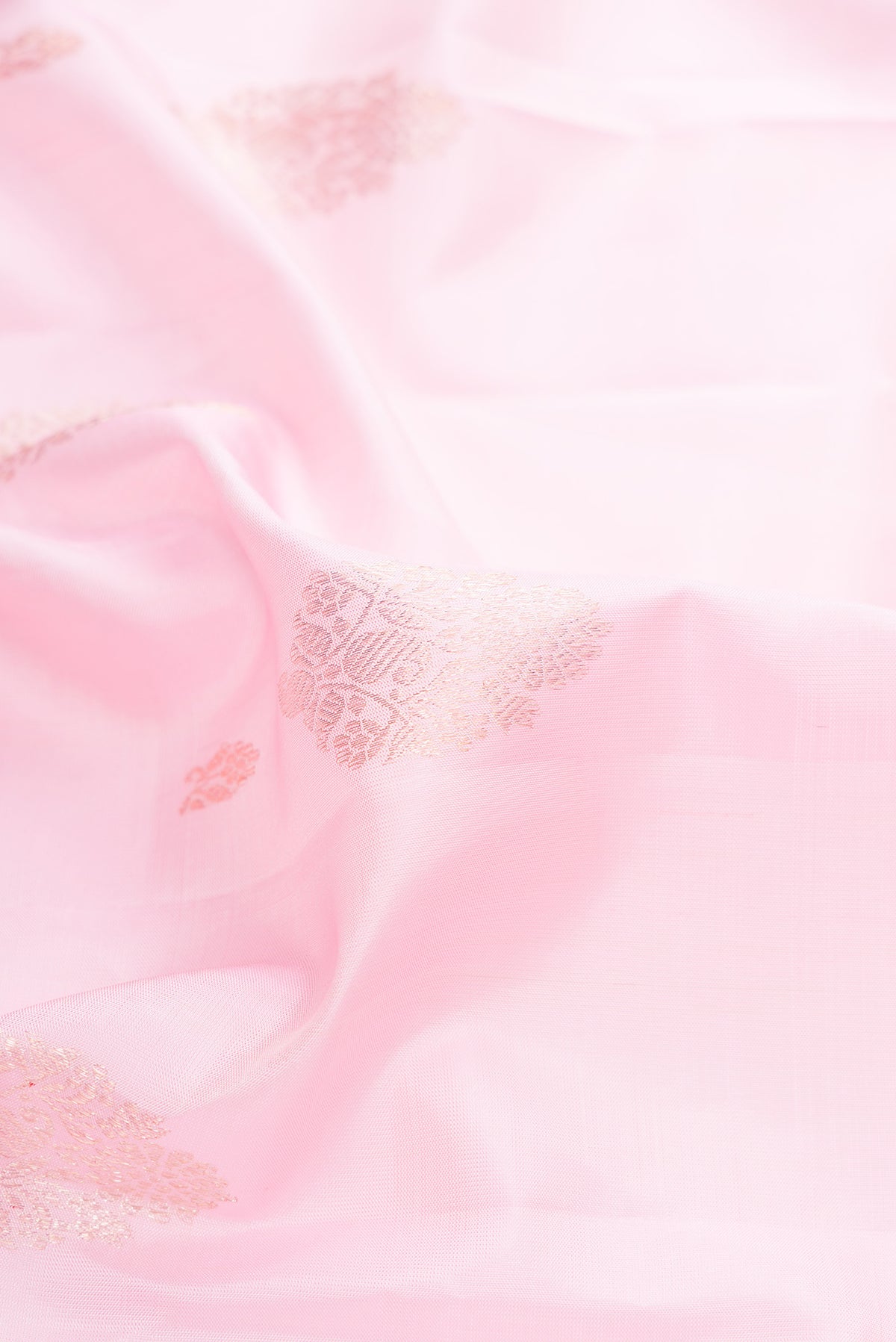 Close up of Pure Silk Rose pink Kanjivaram Saree with Zari Butta on the body and Zari Border.  displaying folds