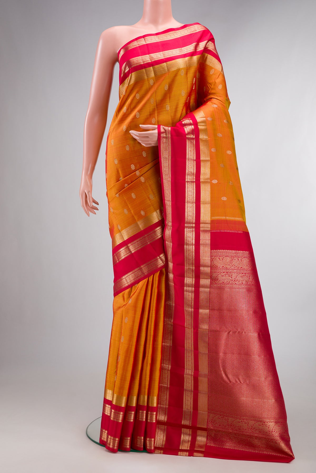 Pure Silk Mustard Kanjivaram Saree with Zari Butta on the body and Zari Border.  displayed on a mannequin