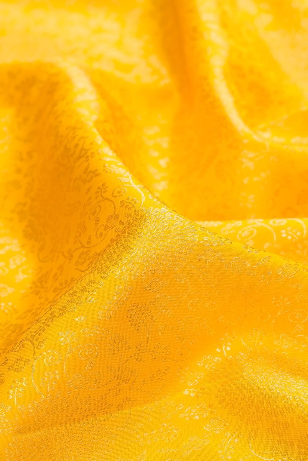 Close up of Pure Silk Yellow Kanchipuram Saree with Zari Brocade on the body and Zari Border.  displaying folds