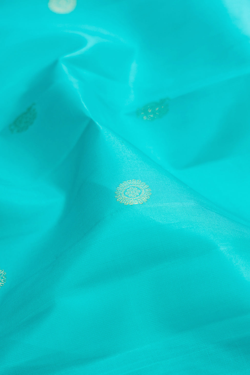 Close up of Pure Silk Sky Blue Kanjivaram Saree with Zari Butta on the body and Zari Border.  displaying folds