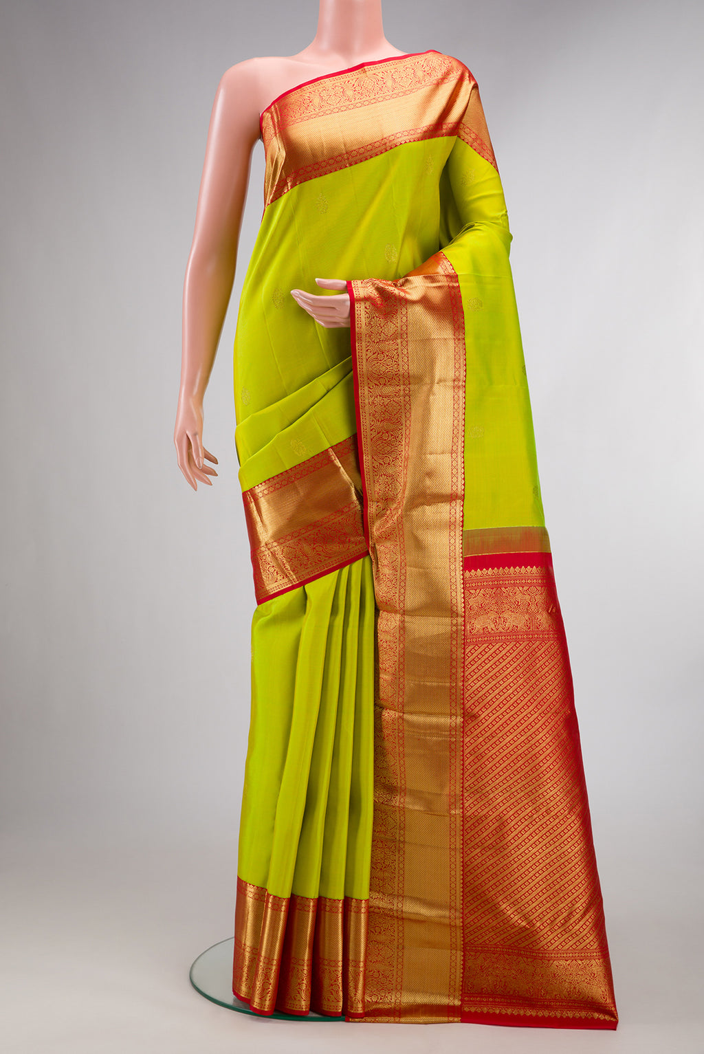 Pure Silk Parrot Green Kanjivaram Saree with Zari Butta on the body and Zari Border.  displayed on a mannequin