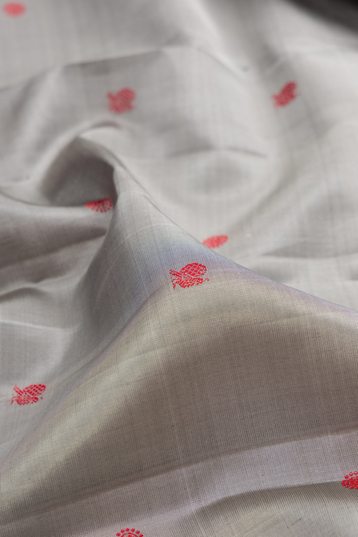 Close up of Pure Silk Grey Kanchipuram Saree with Thread Butta on the body and Thread Border.  displaying folds