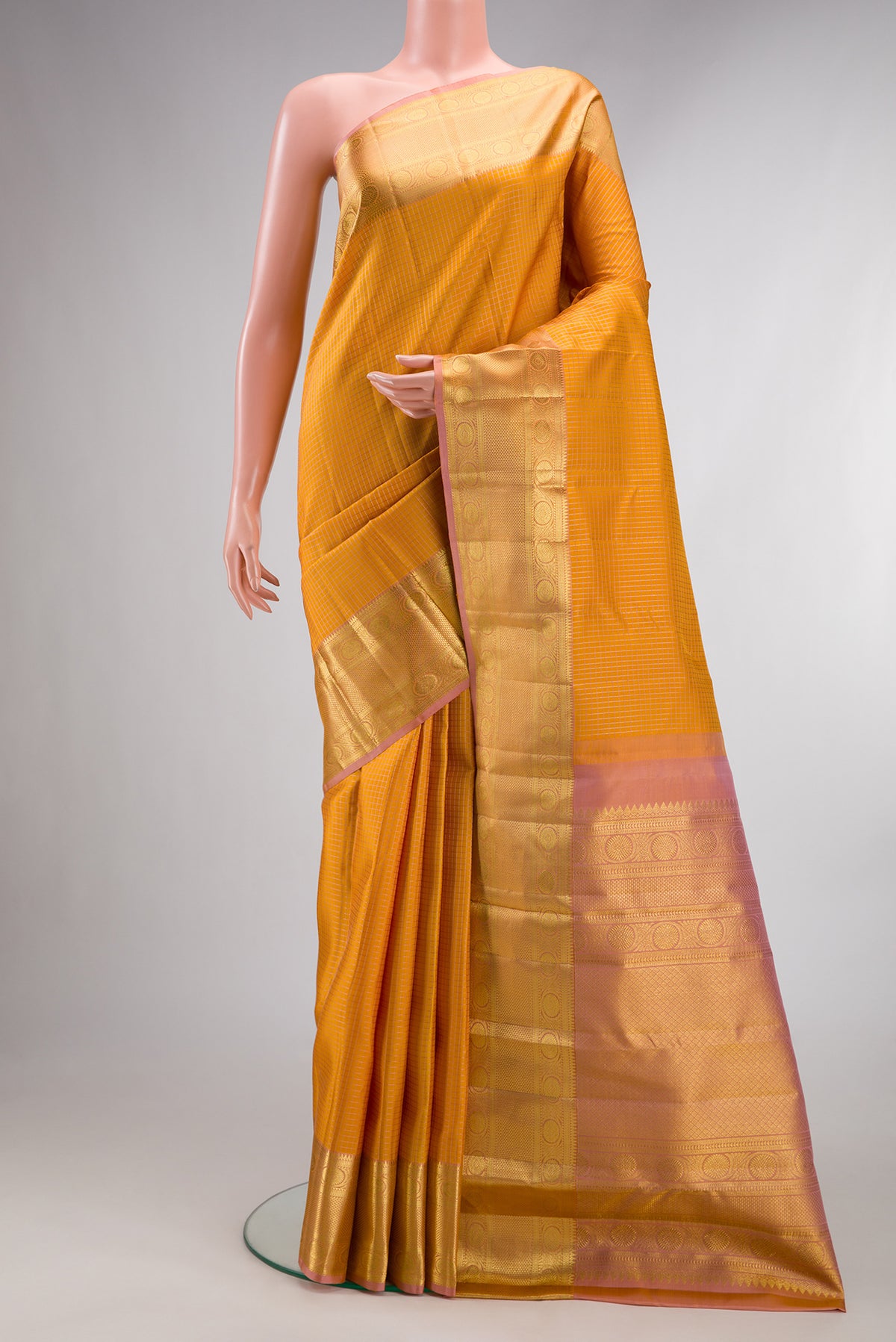 Pure Silk Mustard Kanjivaram Saree with Checked design on the body and Zari Border.  displayed on a mannequin
