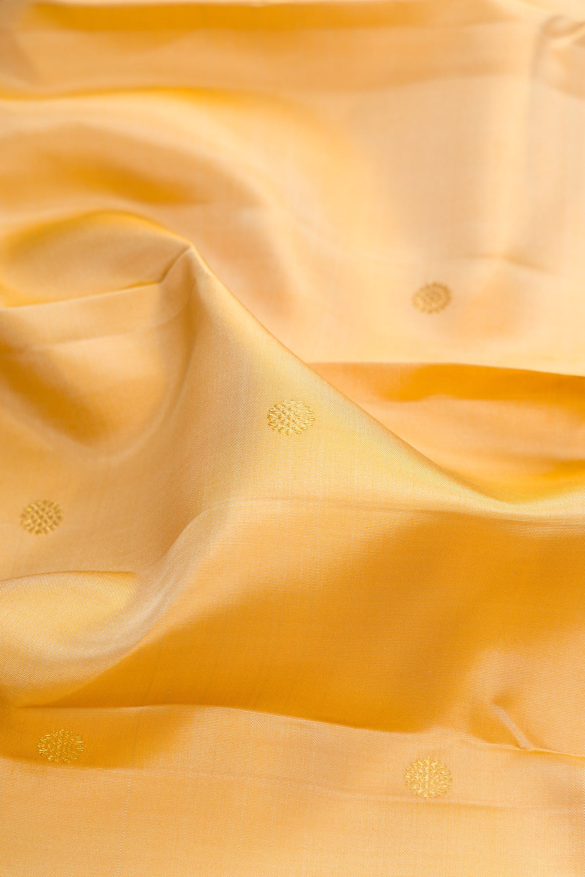 Close up of Pure Silk Sandal Kanchipuram Saree with Zari Butta on the body and Zari Border.  displaying folds