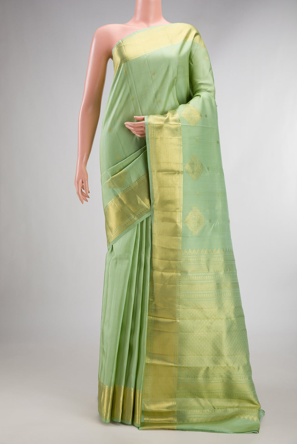 Pure Silk Pista Green Kanchipuram Saree with Zari Butta on the body and Zari Border.  displayed on a mannequin