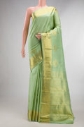 Pure Silk Pista Green Kanchipuram Saree with Zari Butta on the body and Zari Border.  displayed on a mannequin