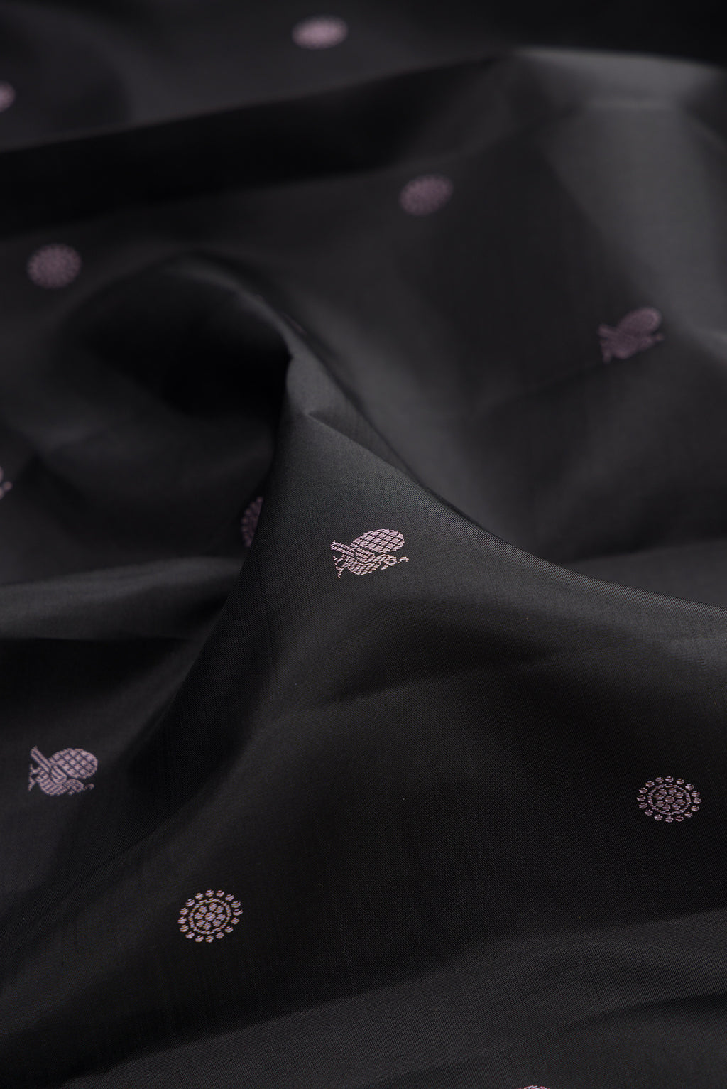 Close up of Pure Silk Black Kanchipuram Saree with Thread Butta on the body and Thread Border.  displaying folds