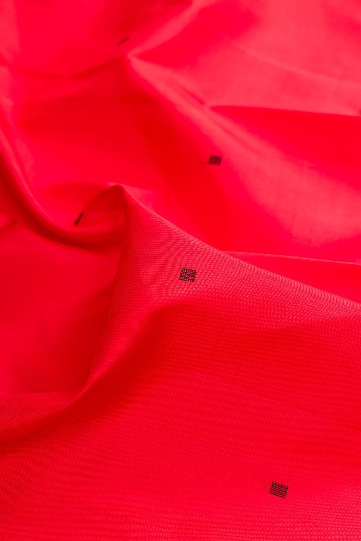 Close up of Pure Silk Pure Zari Brick Orange Kanjivaram Saree with Thread Butta on the body and Thread Border.  displaying folds