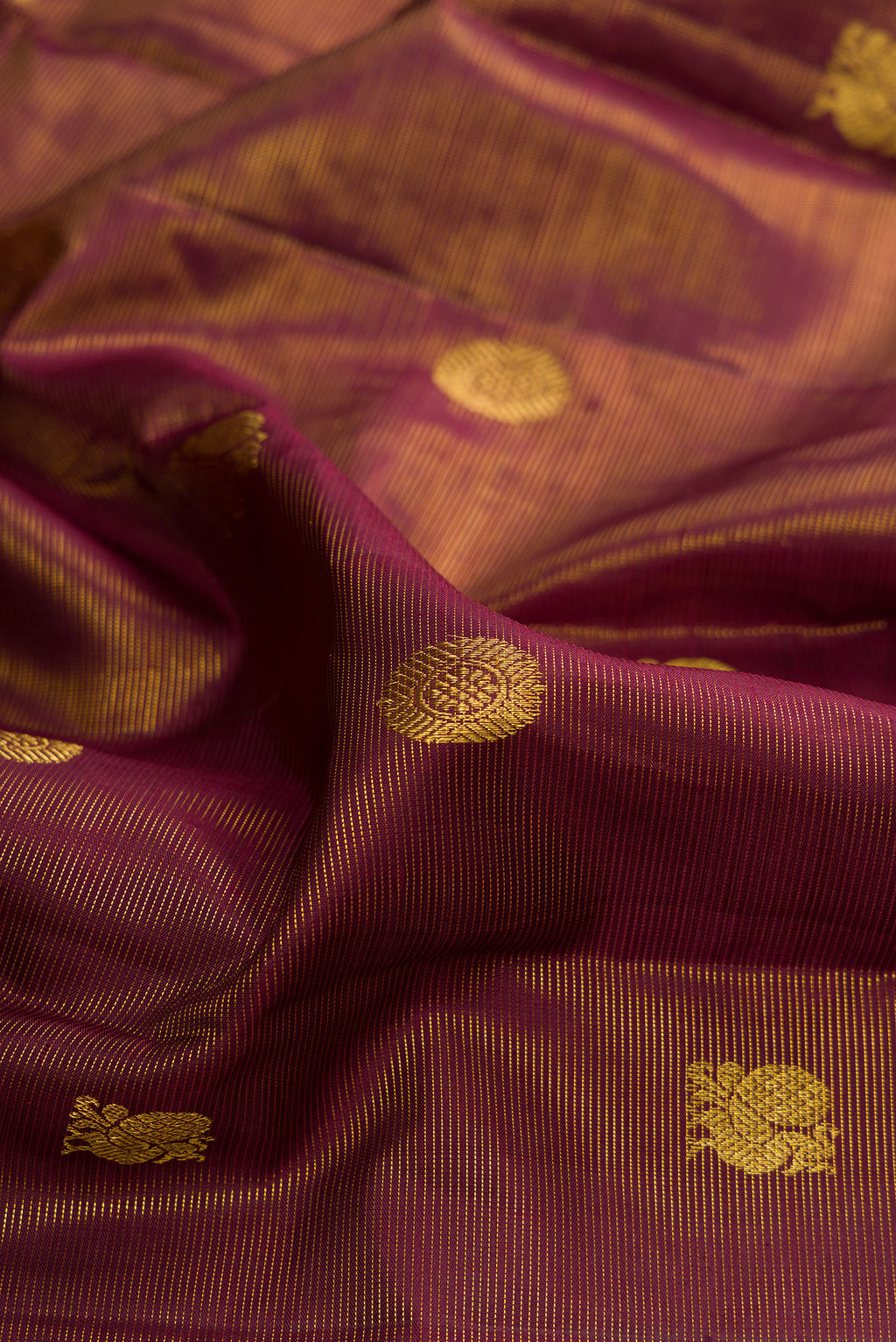 Close up of Pure Silk Maroon Dual Tone Kanjivaram Saree with Stripes on the body and Zari Border.  displaying folds