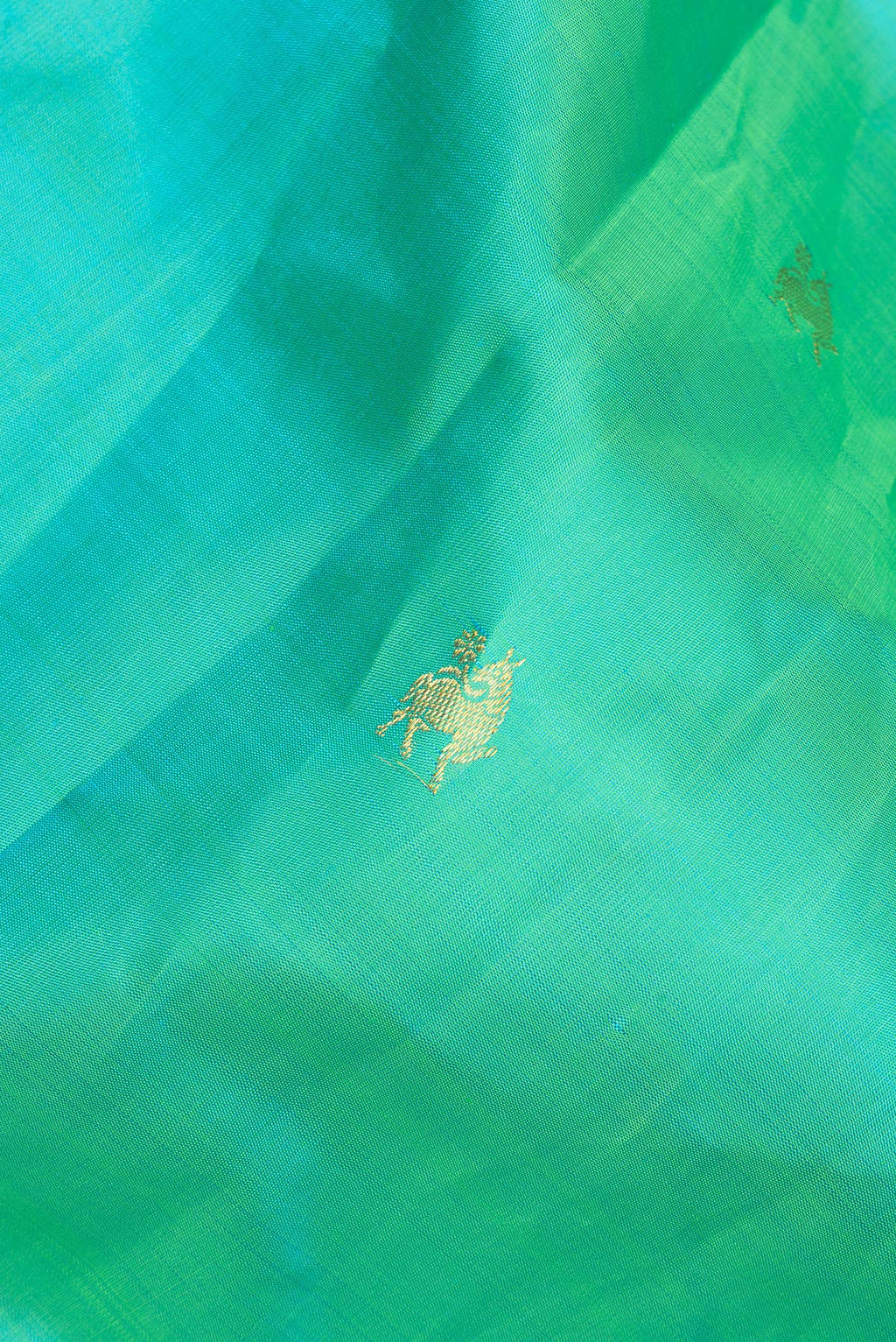 Close up of Pure Silk Sea Green Dual Tone Kanjivaram Saree with Zari Butta on the body and Zari Border.  displaying folds