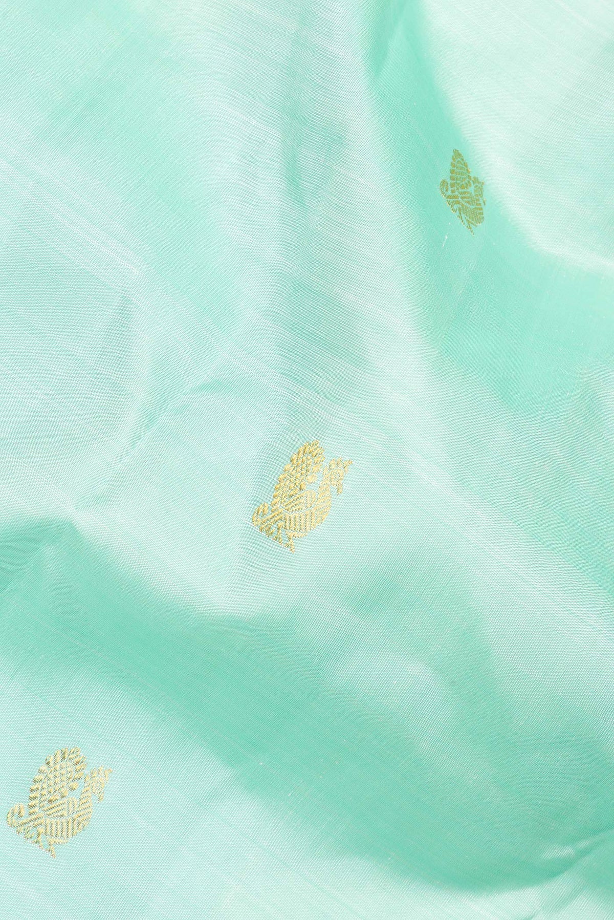 Close up of Pure Silk Pista Green Dual Tone Kanjivaram Saree with Zari Butta on the body and Zari Border.  displaying folds