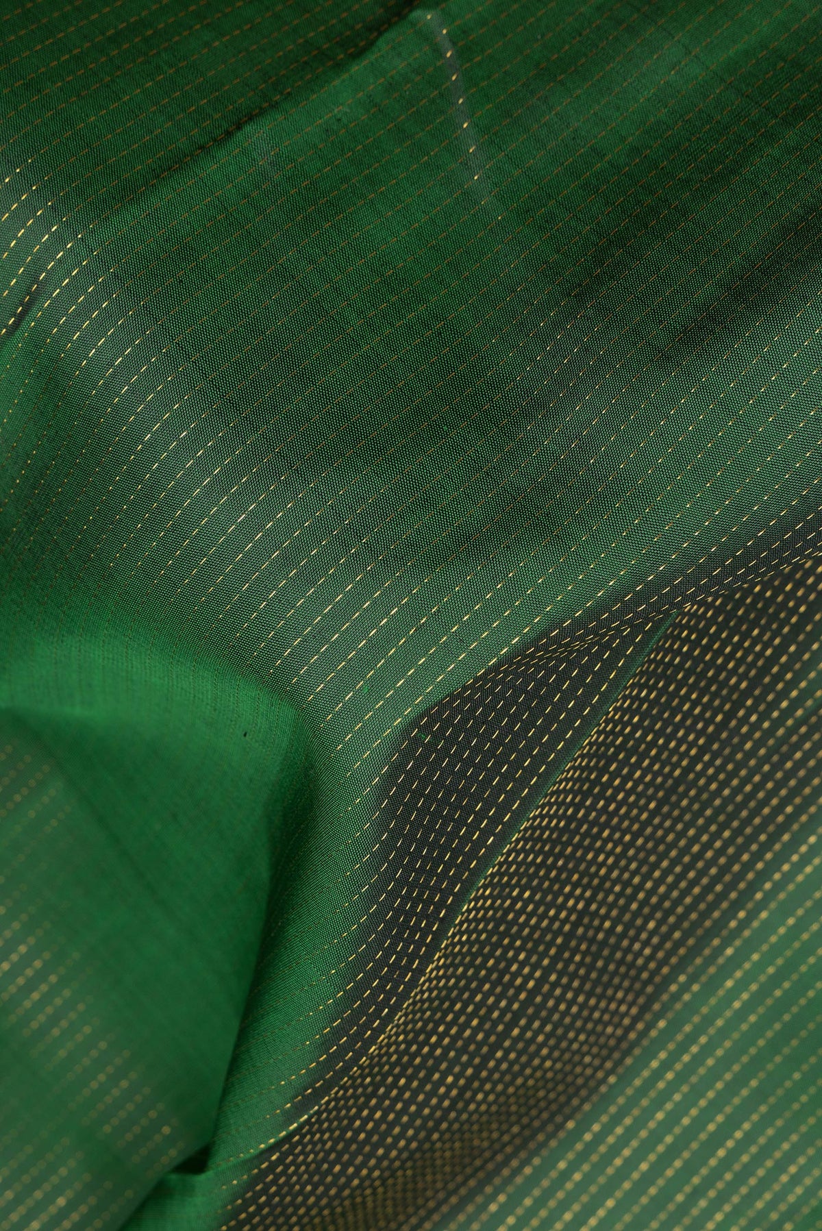 Close up of Pure Silk Bottle Green Kanchipuram Saree with Stripes on the body and Zari Border.  displaying folds