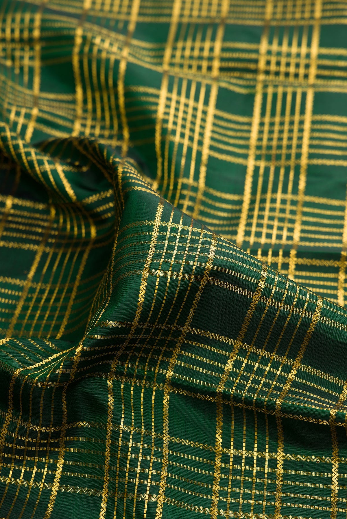 Close up of Pure Silk Bottle Green Kanchipuram Saree with Checked design on the body and Zari Border.  displaying folds