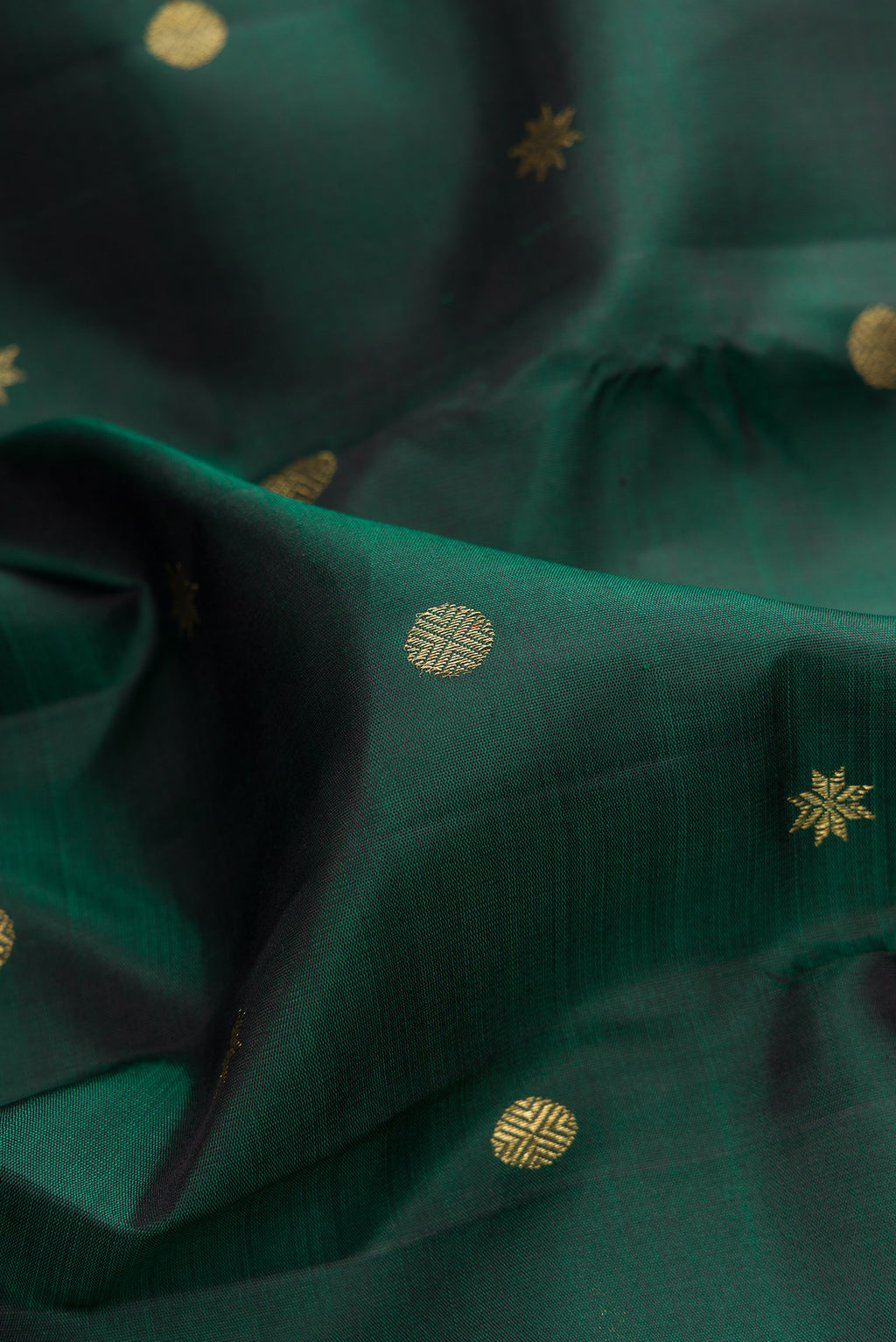 Close up of Pure Silk Pure Zari Bottle Green Kanchipuram Saree with Zari Butta on the body and Zari Border.  displaying folds