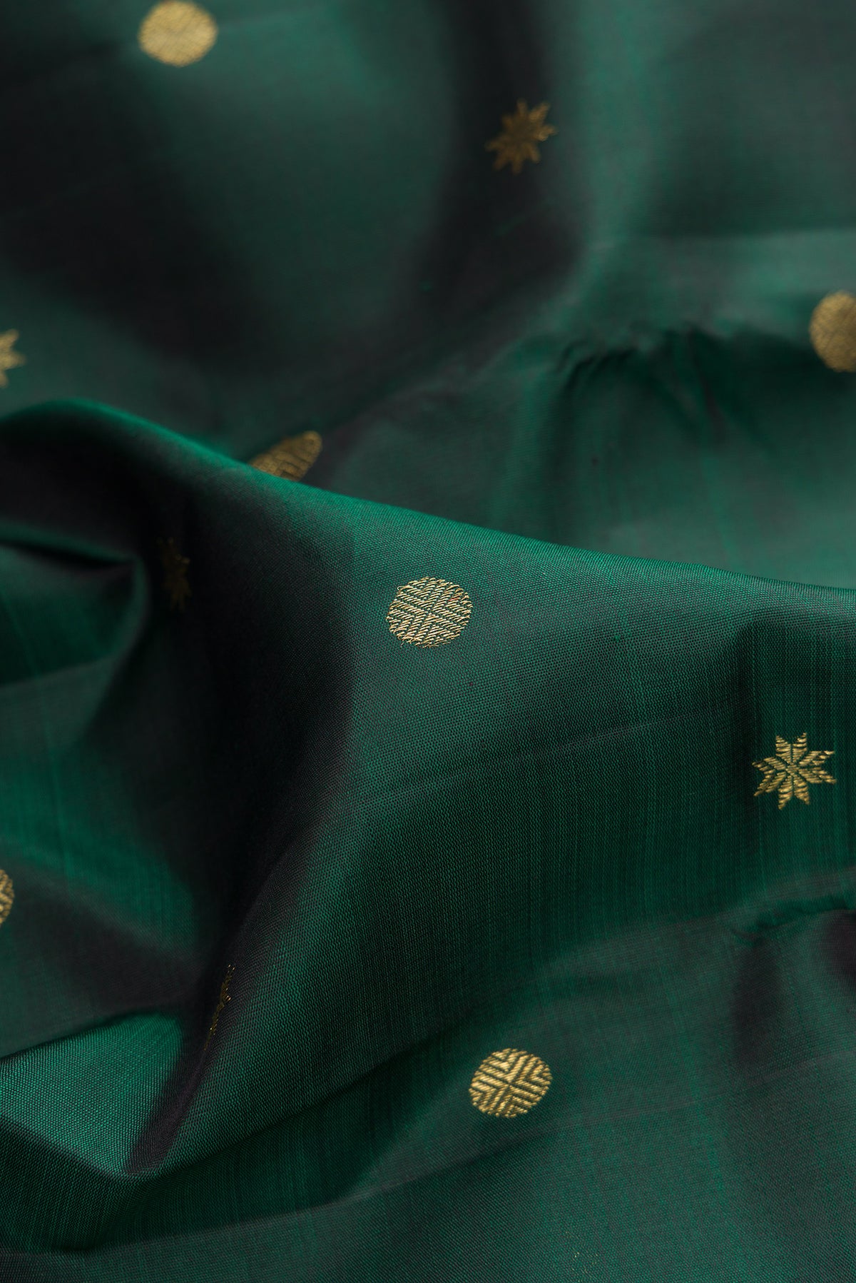 Close up of Pure Silk Pure Zari Bottle Green Kanchipuram Saree with Zari Butta on the body and Zari Border.  displaying folds