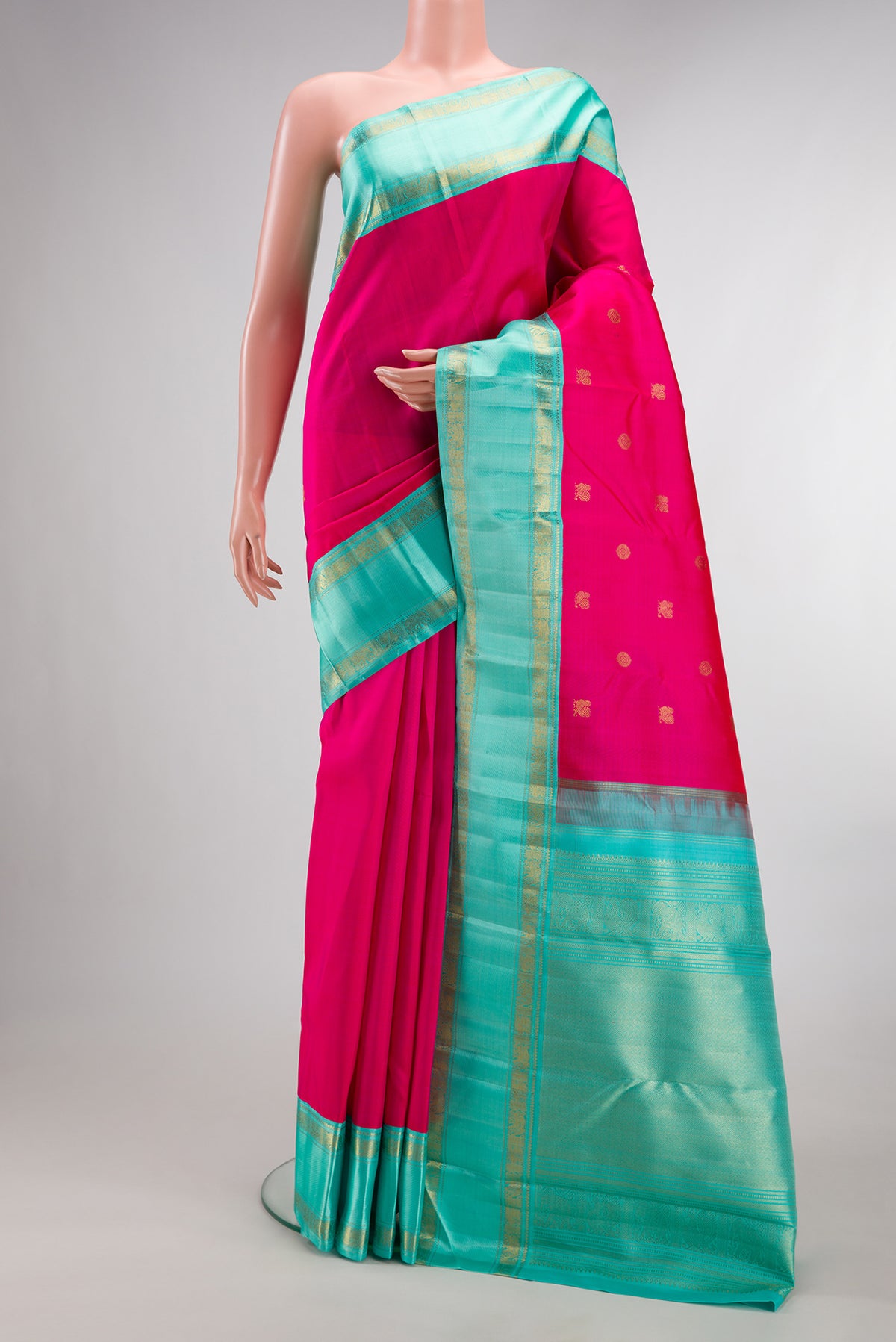 Pure Silk Pure Zari Rani Pink Kanjivaram Saree with Zari Butta on the body and Zari Border.  displayed on a mannequin