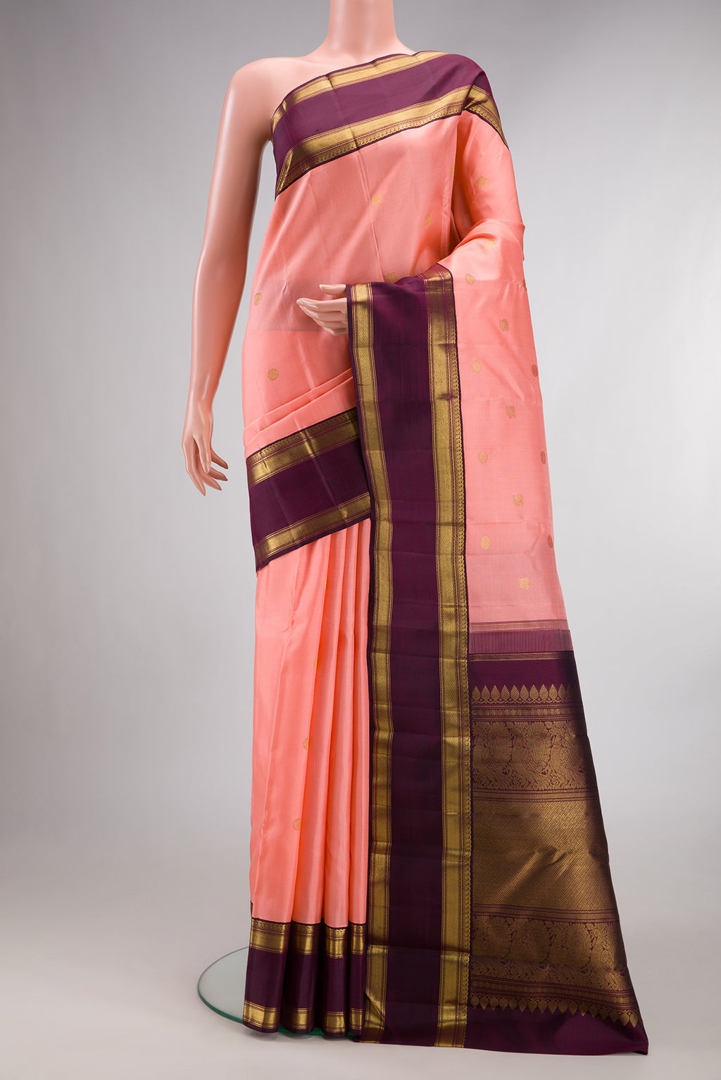 Pure Silk Pure Zari Peach Kanjivaram Saree with Zari Butta on the body and Zari Border.  displayed on a mannequin