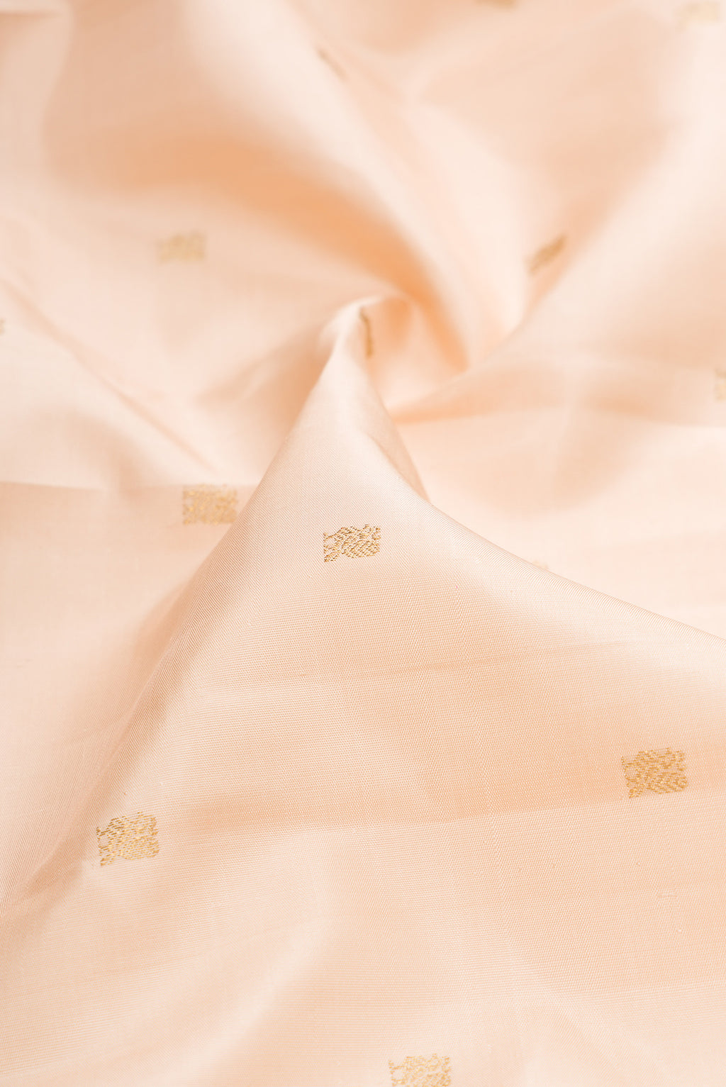 Close up of Pure Silk Pure Zari Cream Dual Tone Kanjivaram Saree with Zari Butta on the body and Zari Border.  displaying folds