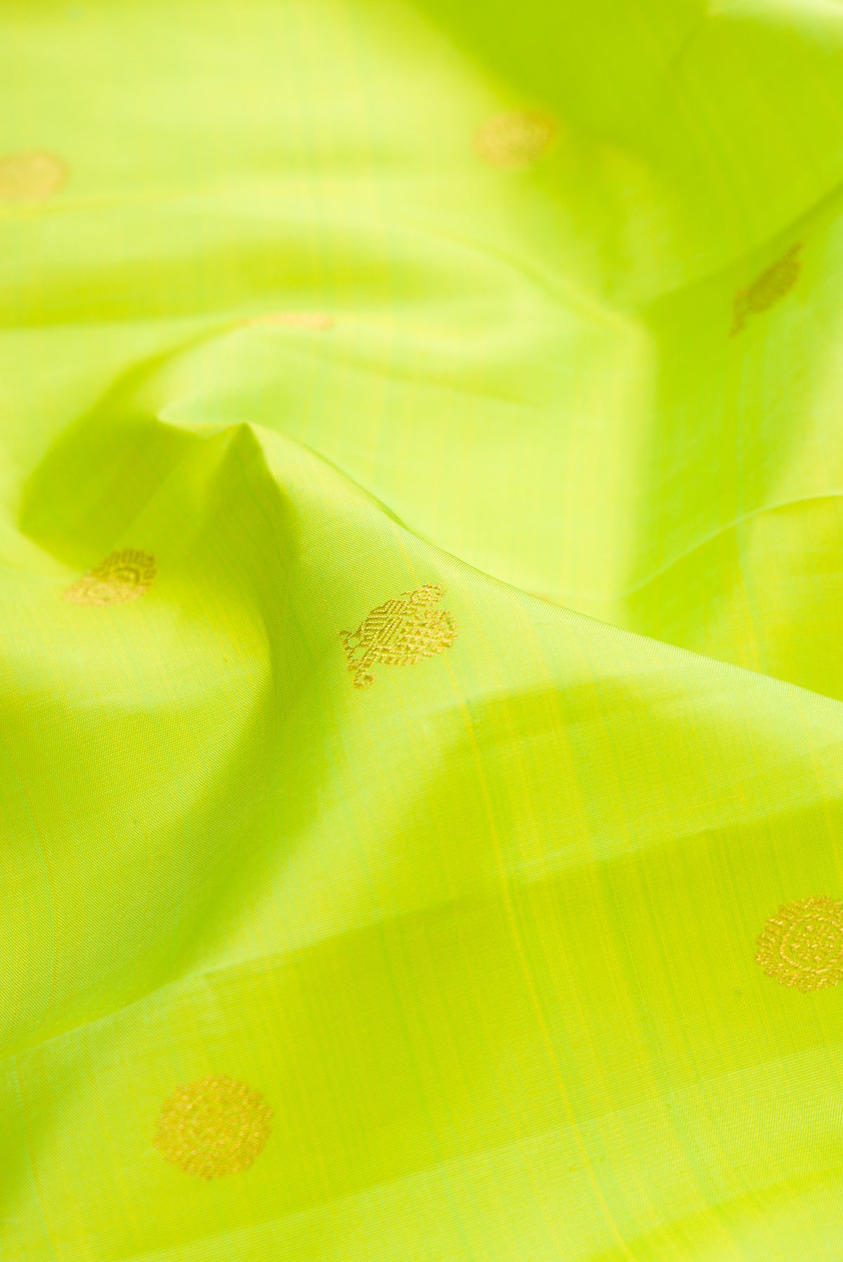 Close up of Pure Silk Pure Zari Parrot Green Kanjivaram Saree with Zari Butta on the body and Fancy Border.  displaying folds