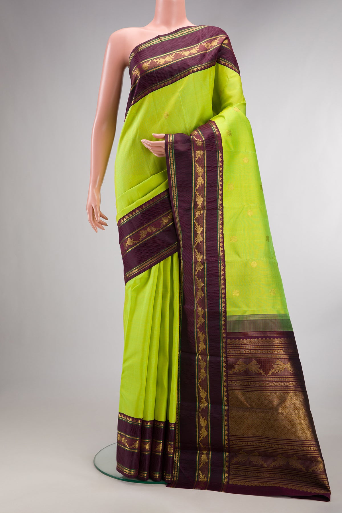 Pure Silk Pure Zari Parrot Green Kanjivaram Saree with Zari Butta on the body and Fancy Border.  displayed on a mannequin