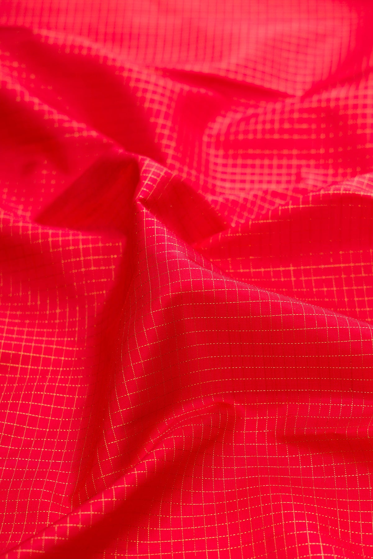 Close up of Pure Silk Pure Zari Red Kanjivaram Saree with Checked design on the body and Zari Border.  displaying folds