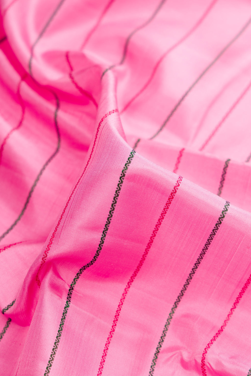 Close up of Pure Silk Rose pink Kanchipuram Saree with Veldhari on the body and Zari Border.  displaying folds