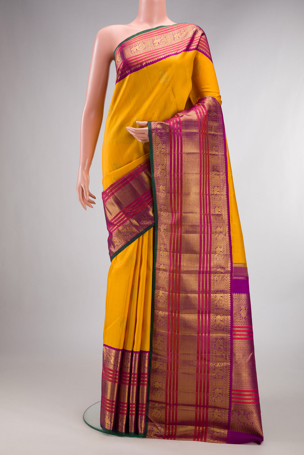 Pure Silk Pure Zari Mustard Kanchipuram Saree with Zari Butta on the body and Zari Border.  displayed on a mannequin