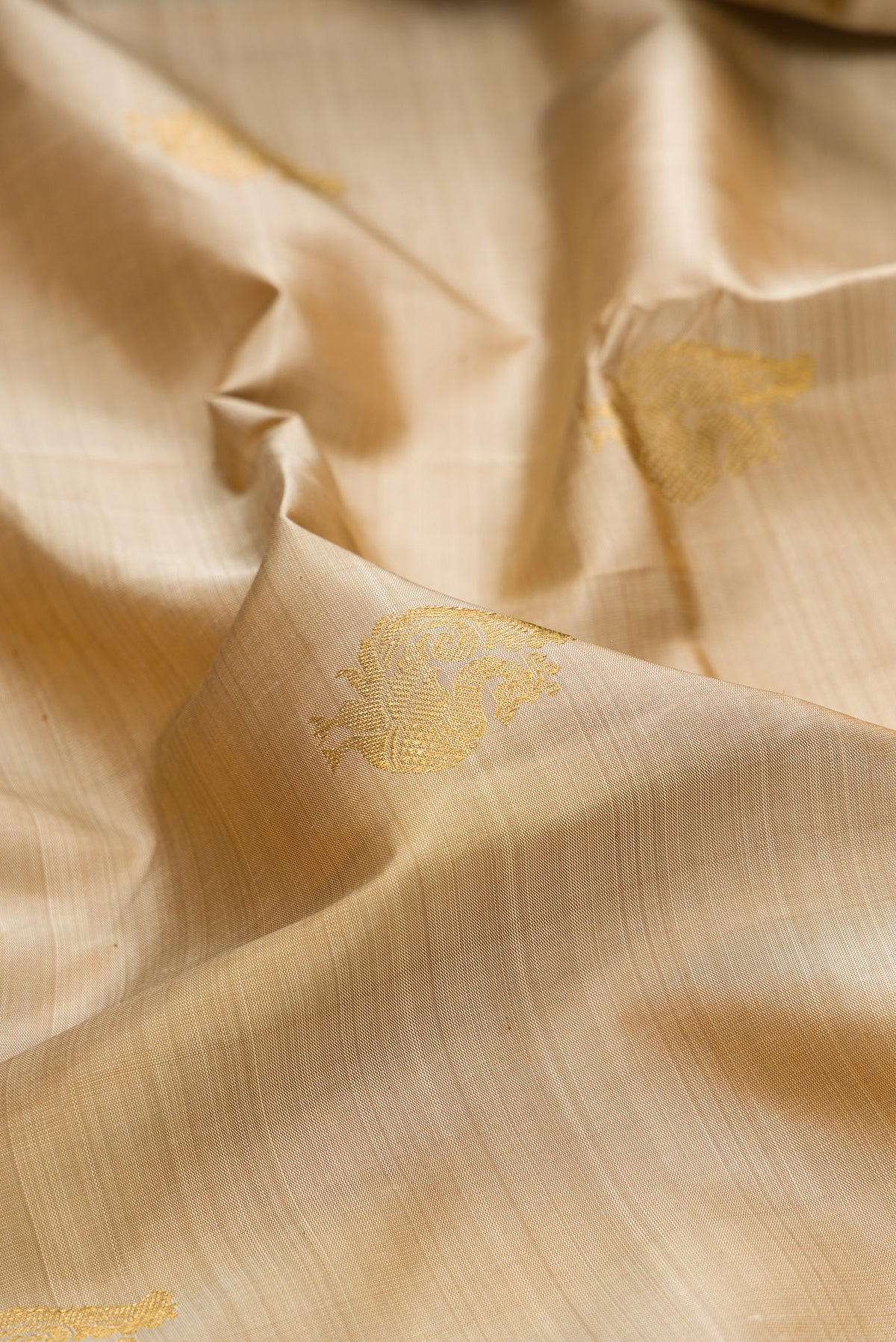 Close up of Pure Silk Pure Zari Dark Beige Kanchipuram Saree with Zari Butta on the body and Zari Border.  displaying folds