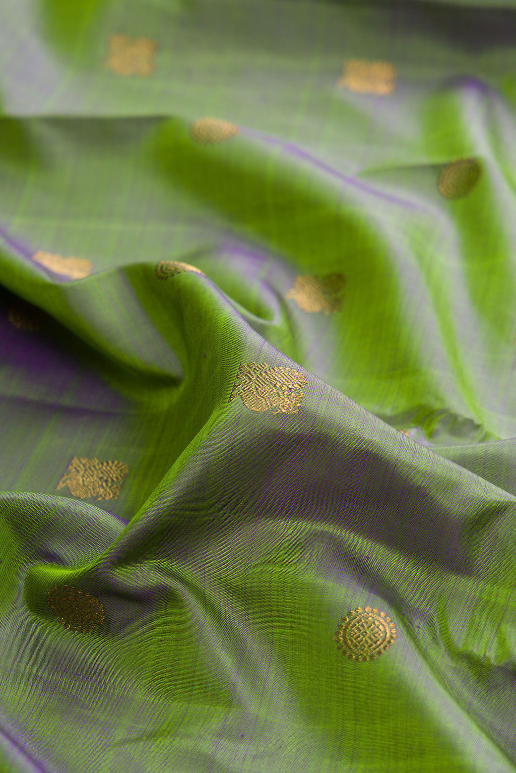 Close up of Pure Silk Pure Zari Green Kanchipuram Saree with Zari Butta on the body and Zari Border.  displaying folds