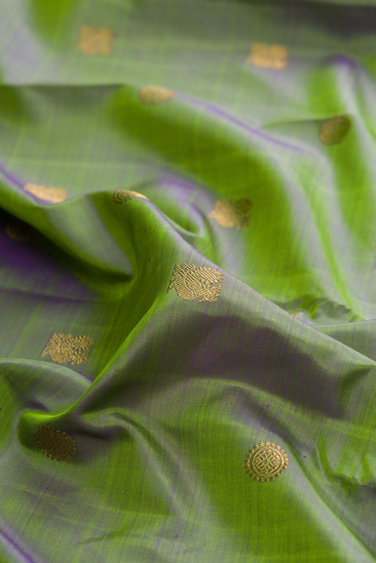 Close up of Pure Silk Pure Zari Green Kanchipuram Saree with Zari Butta on the body and Zari Border.  displaying folds
