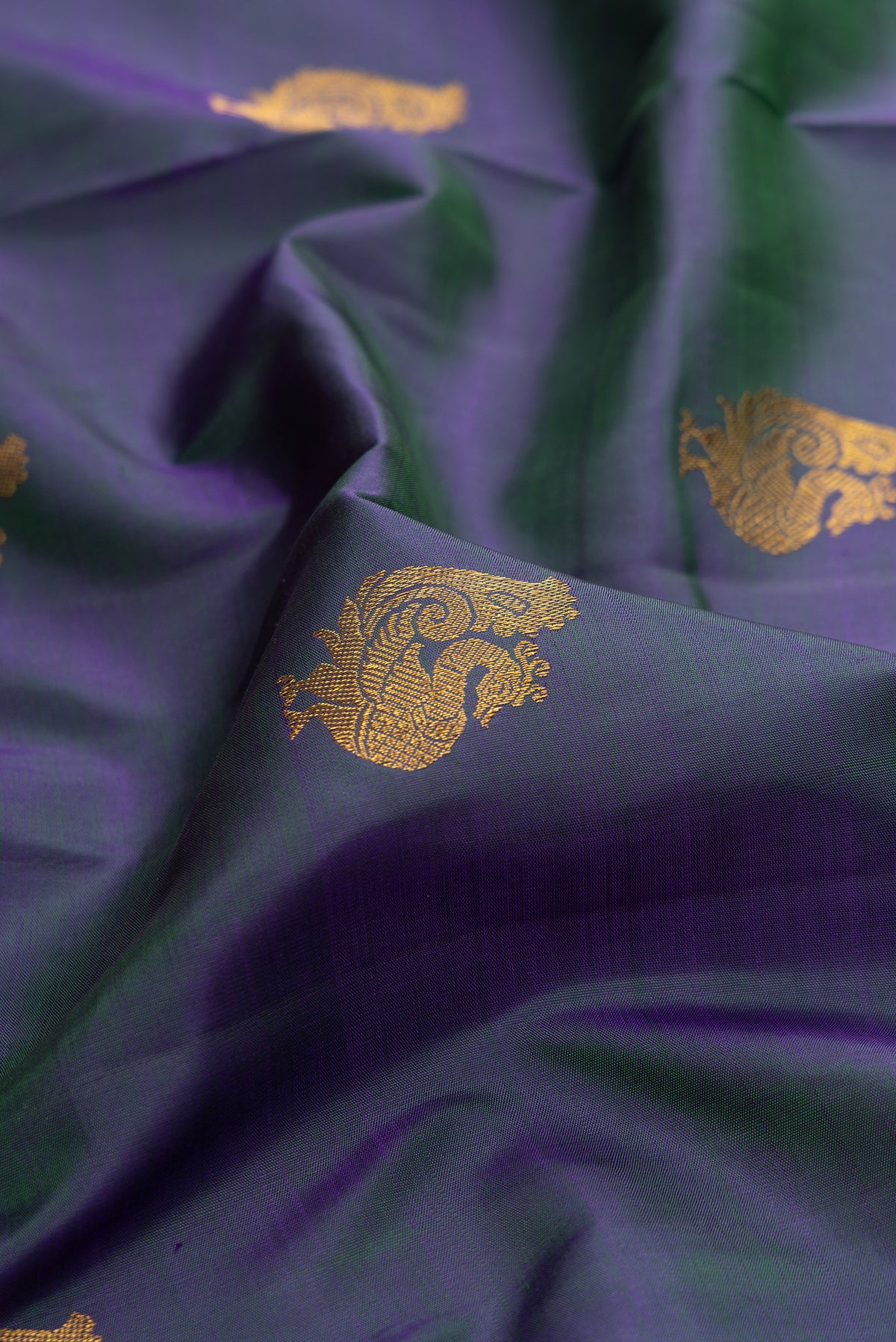 Close up of Pure Silk Pure Zari Peacock Blue Dual Tone Kanchipuram Saree with Zari Butta on the body and Zari Border.  displaying folds