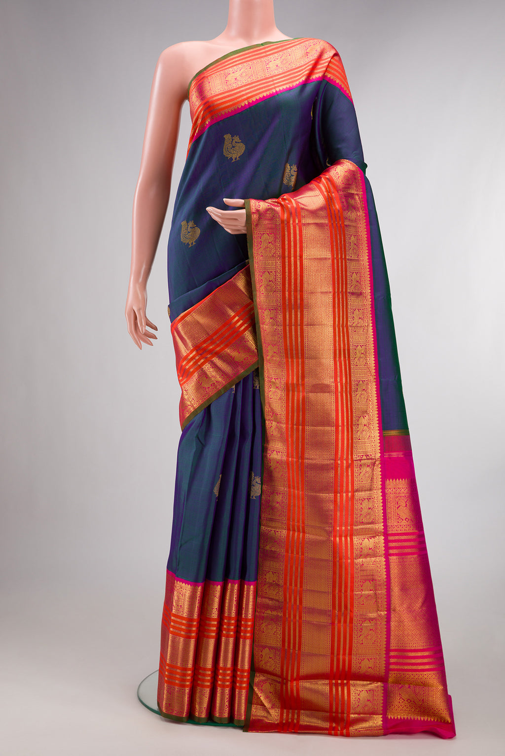 Pure Silk Pure Zari Peacock Blue Dual Tone Kanchipuram Saree with Zari Butta on the body and Zari Border.  displayed on a mannequin