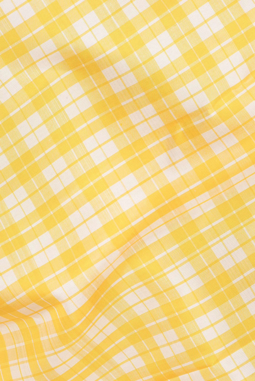 Close up of Pure Silk Yellow Dual Tone Kanjivaram Saree with Checked design on the body and Zari Border.  displaying folds