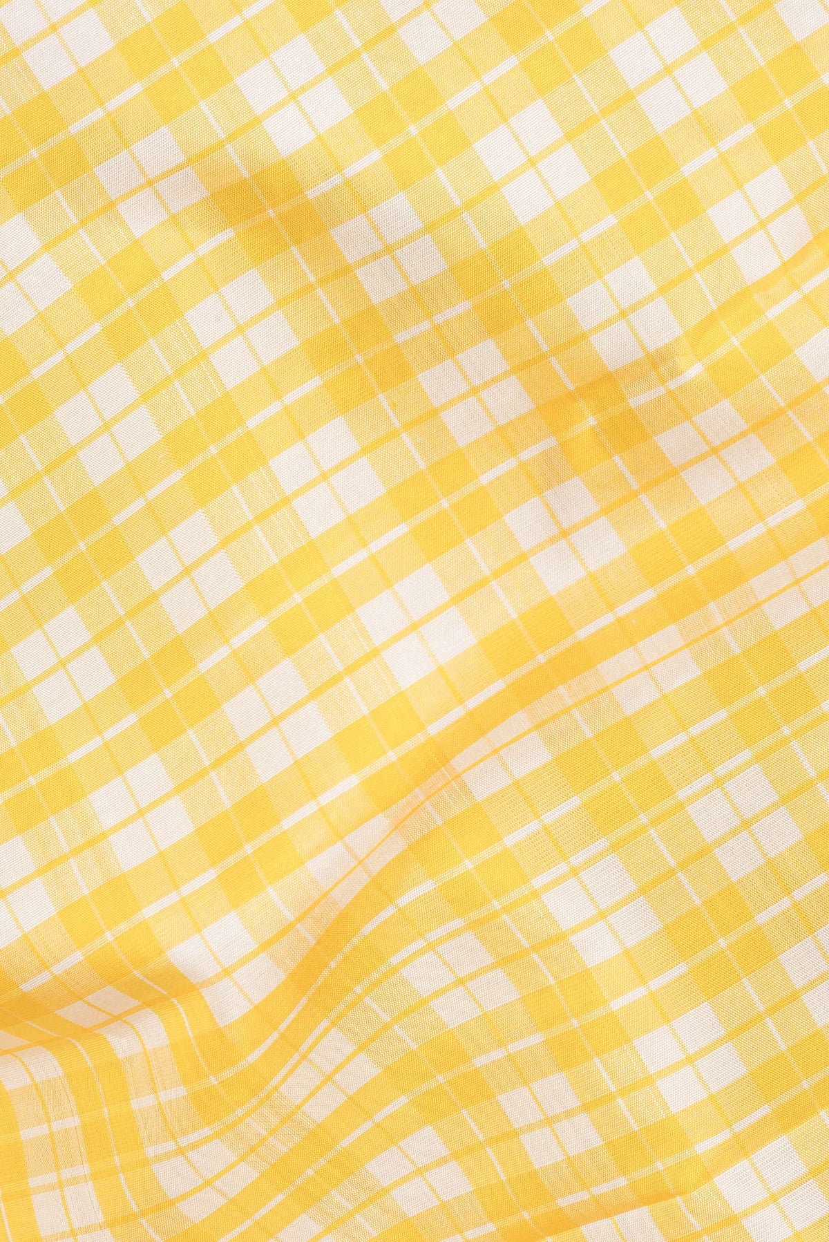 Close up of Pure Silk Yellow Dual Tone Kanjivaram Saree with Checked design on the body and Zari Border.  displaying folds