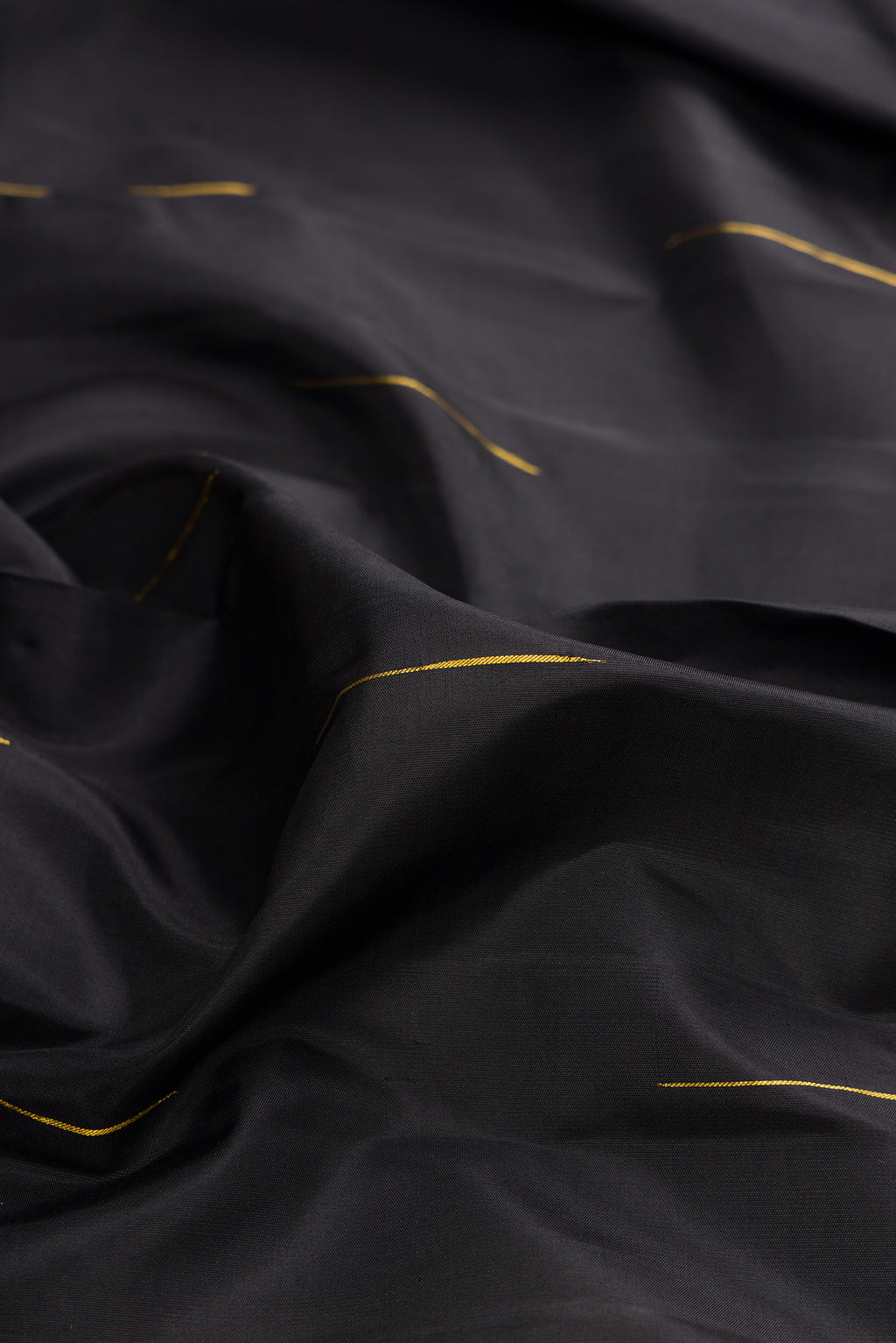 Close up of Pure Silk Black Kanjivaram Saree with Zari Butta on the body and Temple Border.  displaying folds