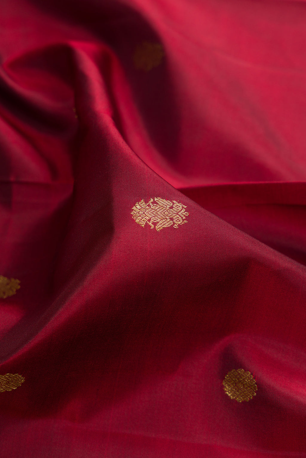 Close up of Pure Silk Maroon Kanjivaram Saree with Zari Butta on the body and Zari Border.  displaying folds
