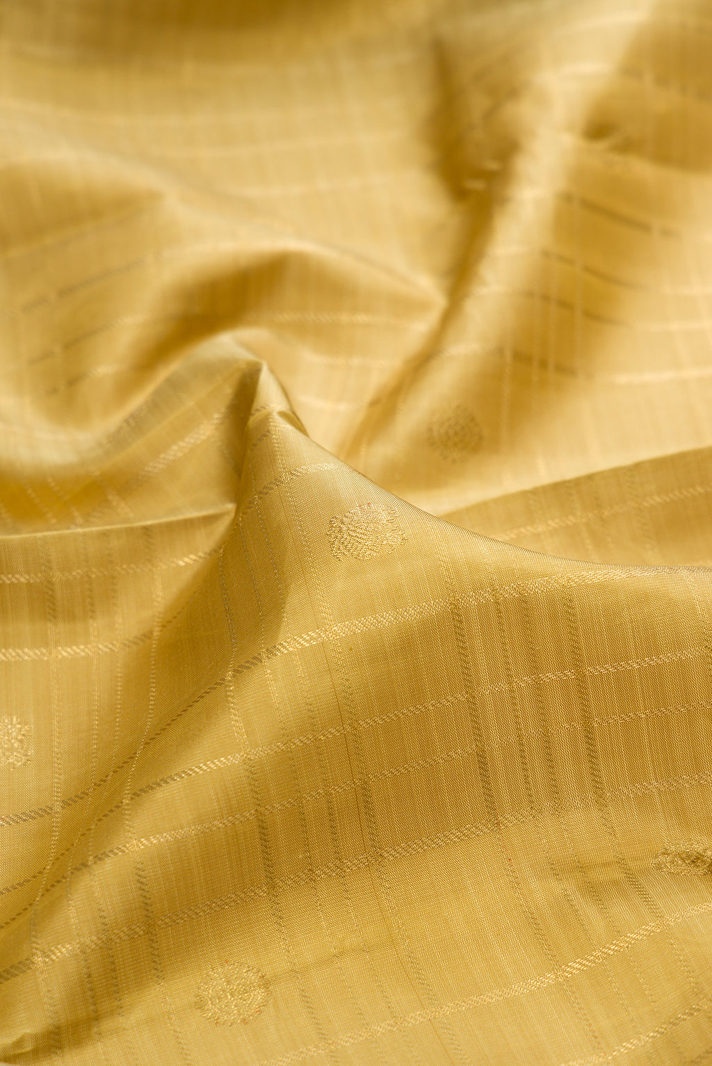 Close up of Pure Silk Pure Zari Gold Dual Tone Kanjivaram Saree with Zari Butta on the body and Zari Border.  displaying folds