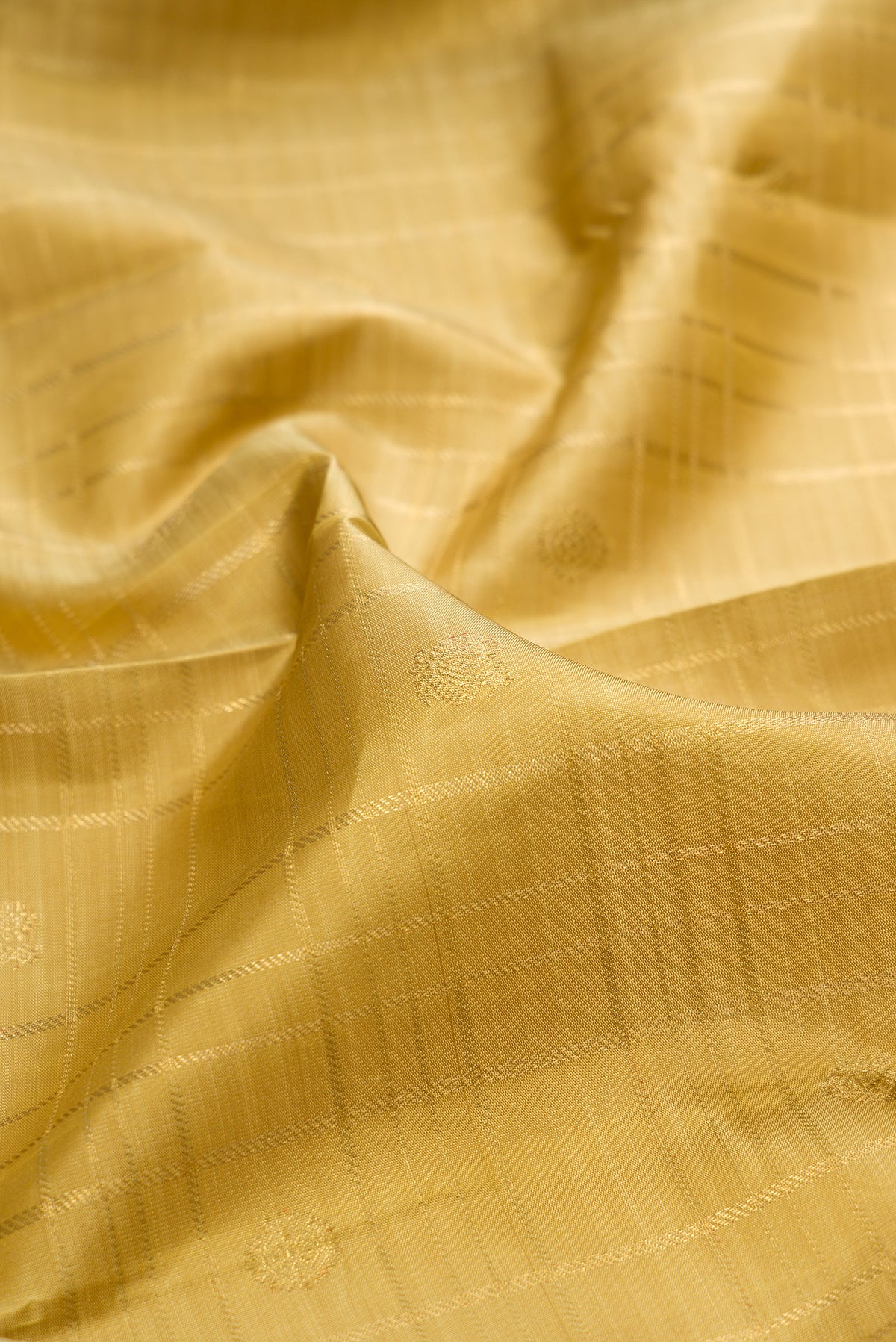 Close up of Pure Silk Pure Zari Gold Dual Tone Kanjivaram Saree with Zari Butta on the body and Zari Border.  displaying folds