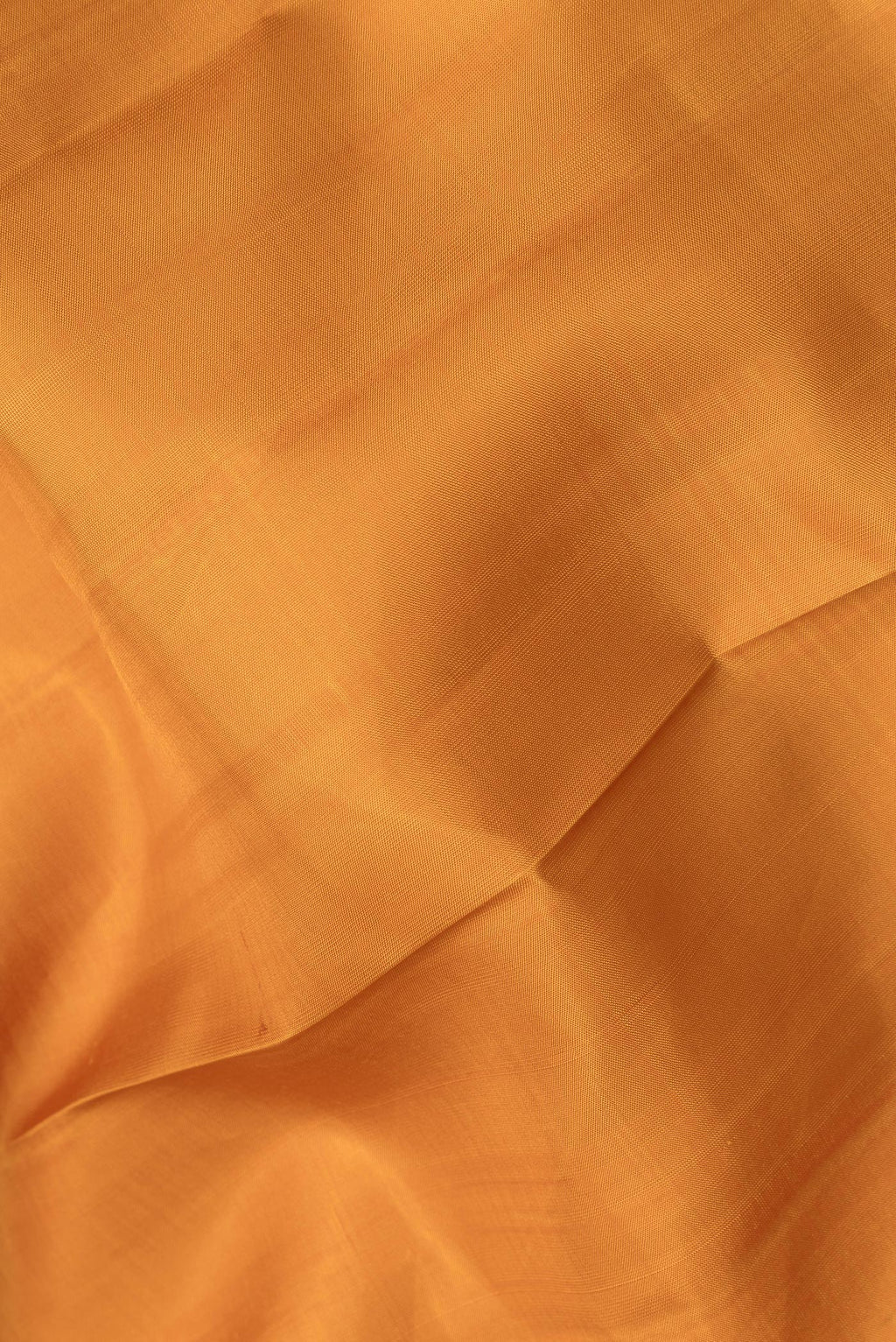 Close up of Pure Silk Mustard Dual Tone Kanchipuram Saree with Plain Body and Zari Border.  displaying folds