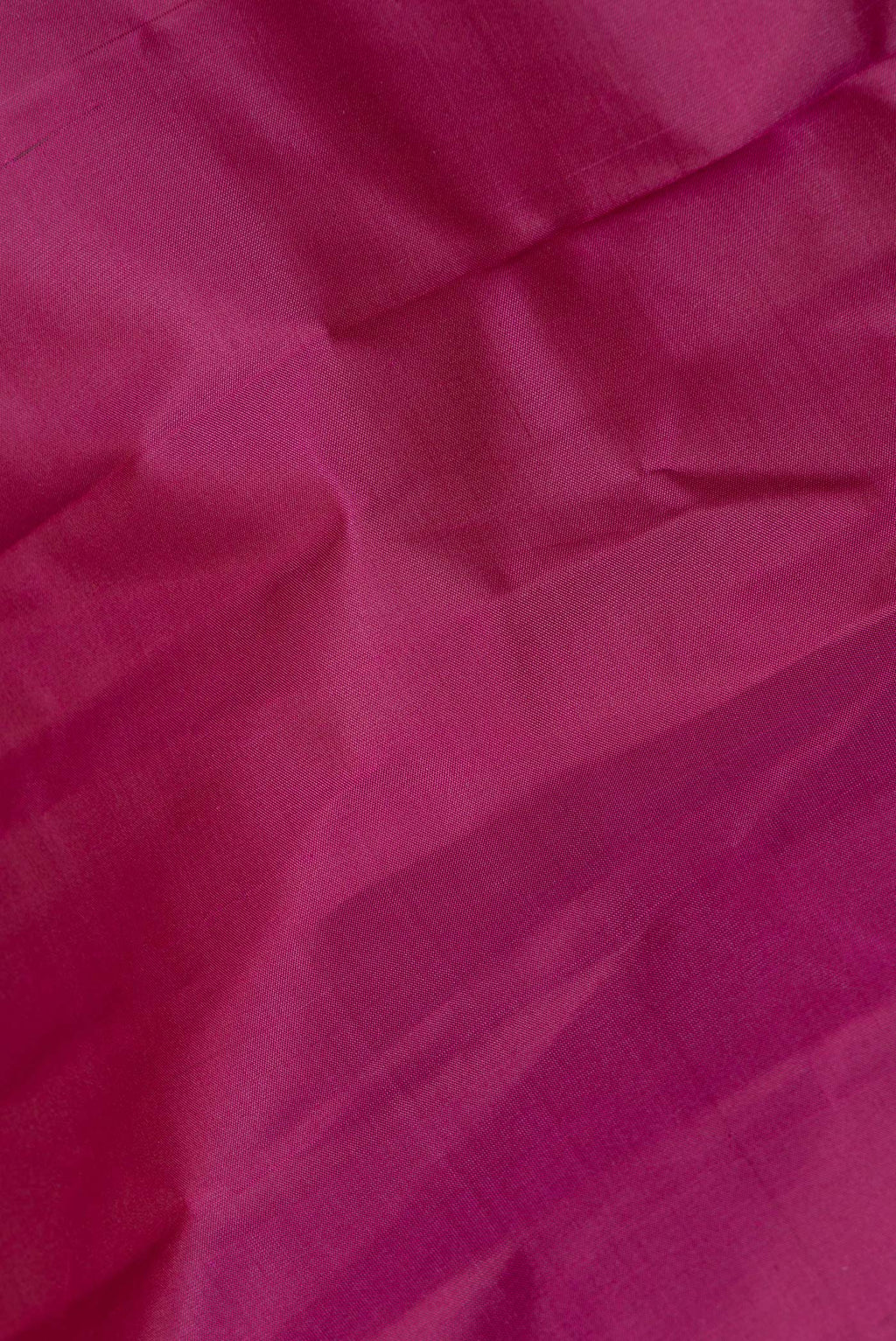 Close up of Pure Silk Magenta Dual Tone Kanchipuram Saree with Plain Body and Zari Border.  displaying folds