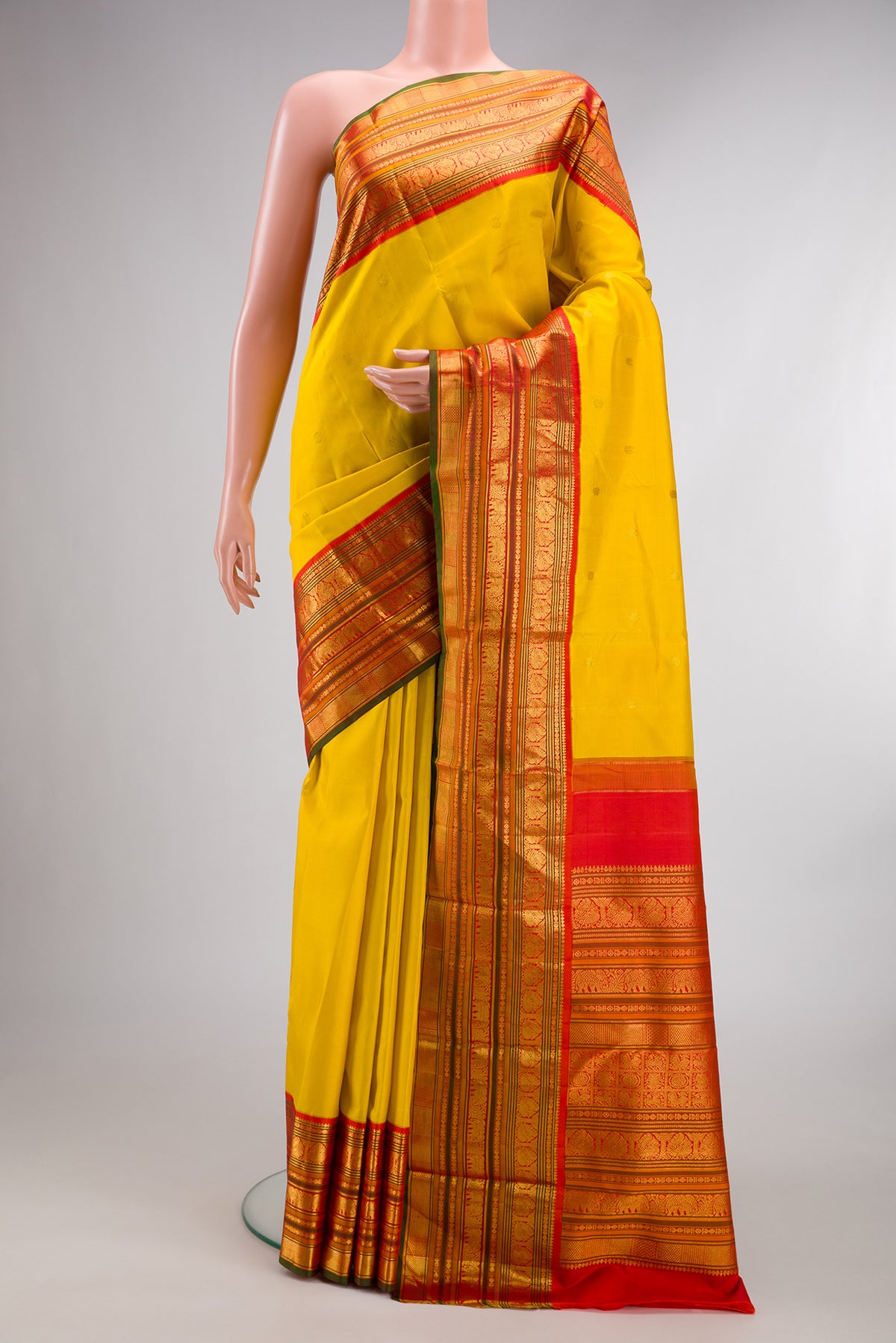 Pure Silk Yellow Kanchipuram Saree with Zari Butta on the body and Zari Border.  displayed on a mannequin
