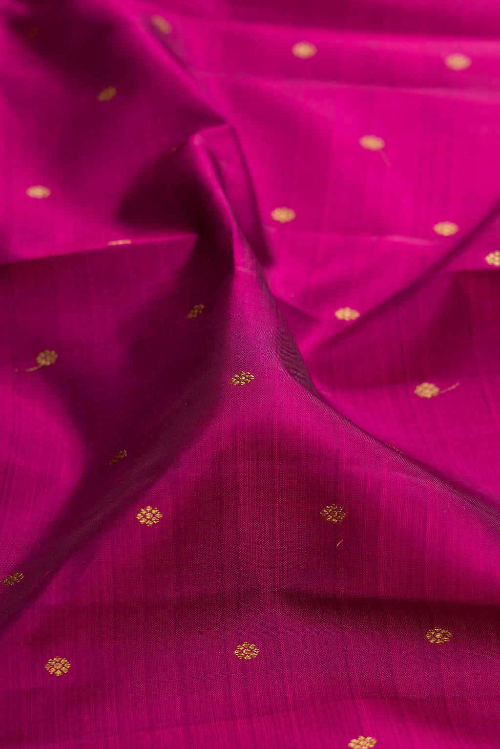Close up of Pure Silk Pure Zari Magenta Kanjivaram Saree with Zari Butta on the body and Zari Border.  displaying folds