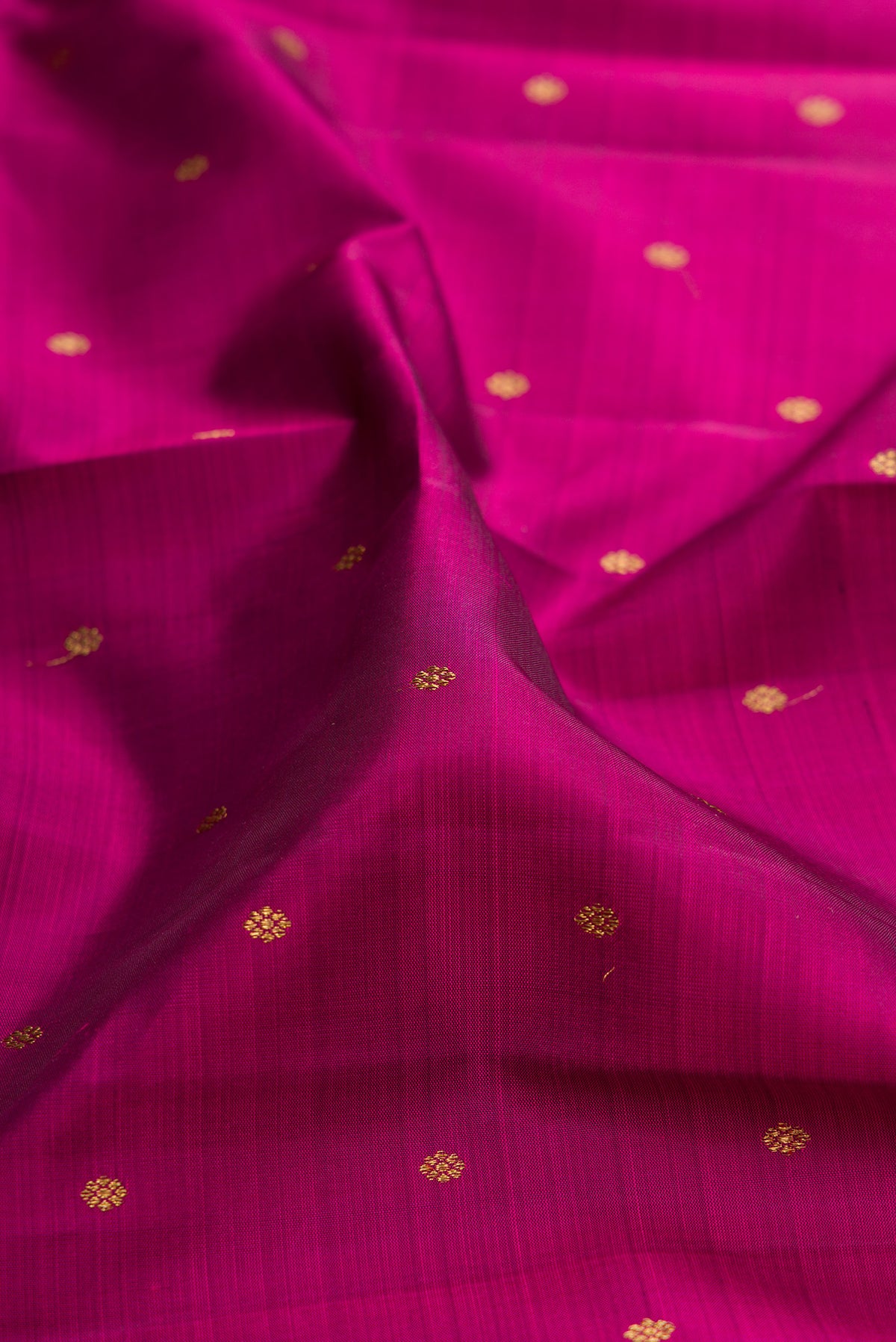 Close up of Pure Silk Pure Zari Magenta Kanjivaram Saree with Zari Butta on the body and Zari Border.  displaying folds