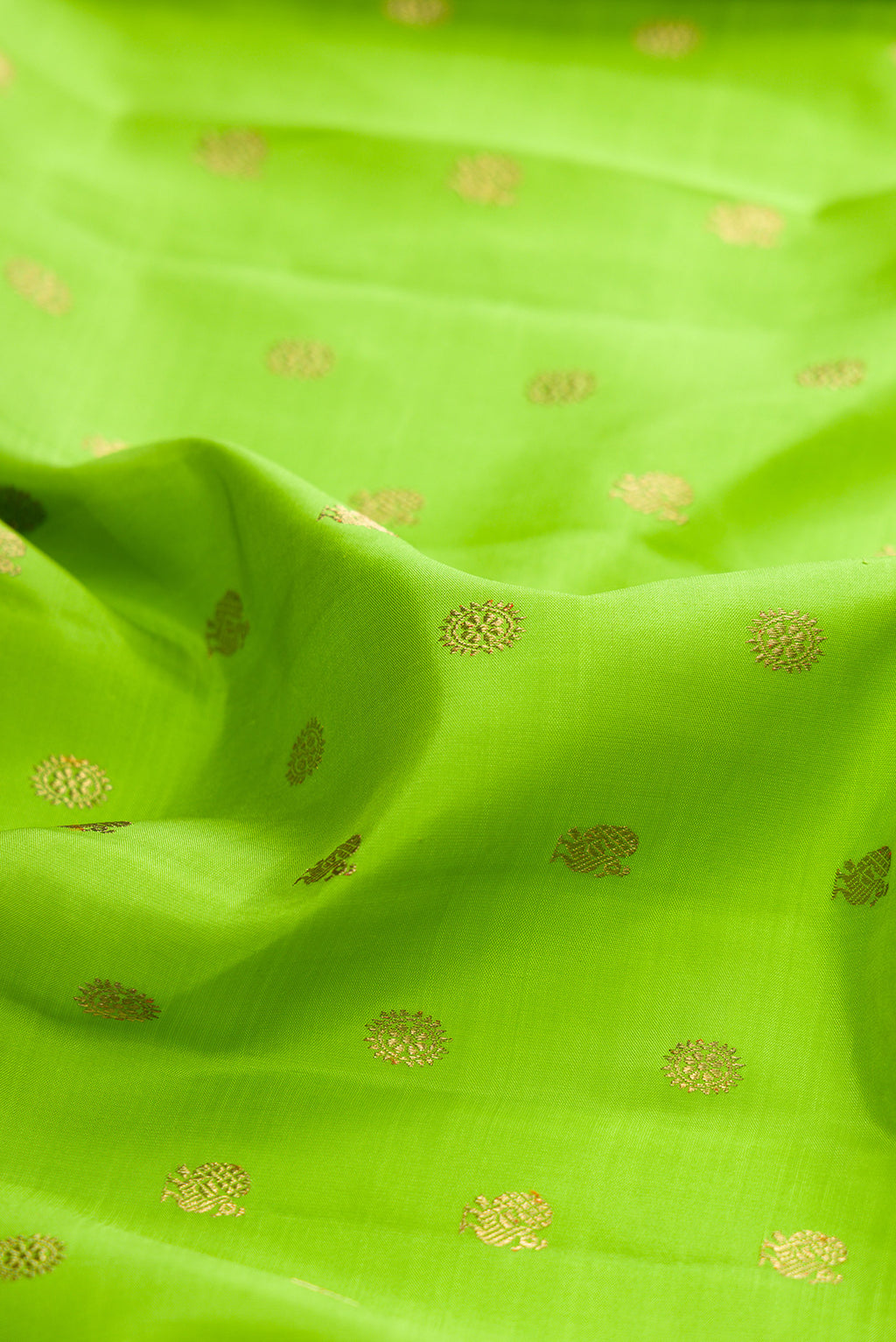 Close up of Pure Silk Pure Zari Parrot Green Dual Tone Kanjivaram Saree with Zari Butta on the body and Zari Border.  displaying folds