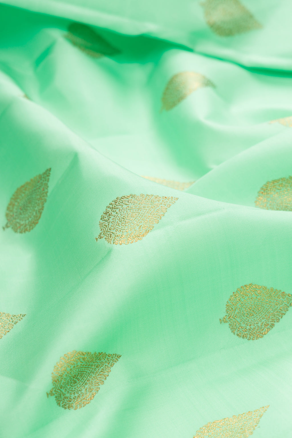 Close up of Pure Silk Pure Zari Sea Green Kanjivaram Saree with Zari Butta on the body and Zari Border.  displaying folds