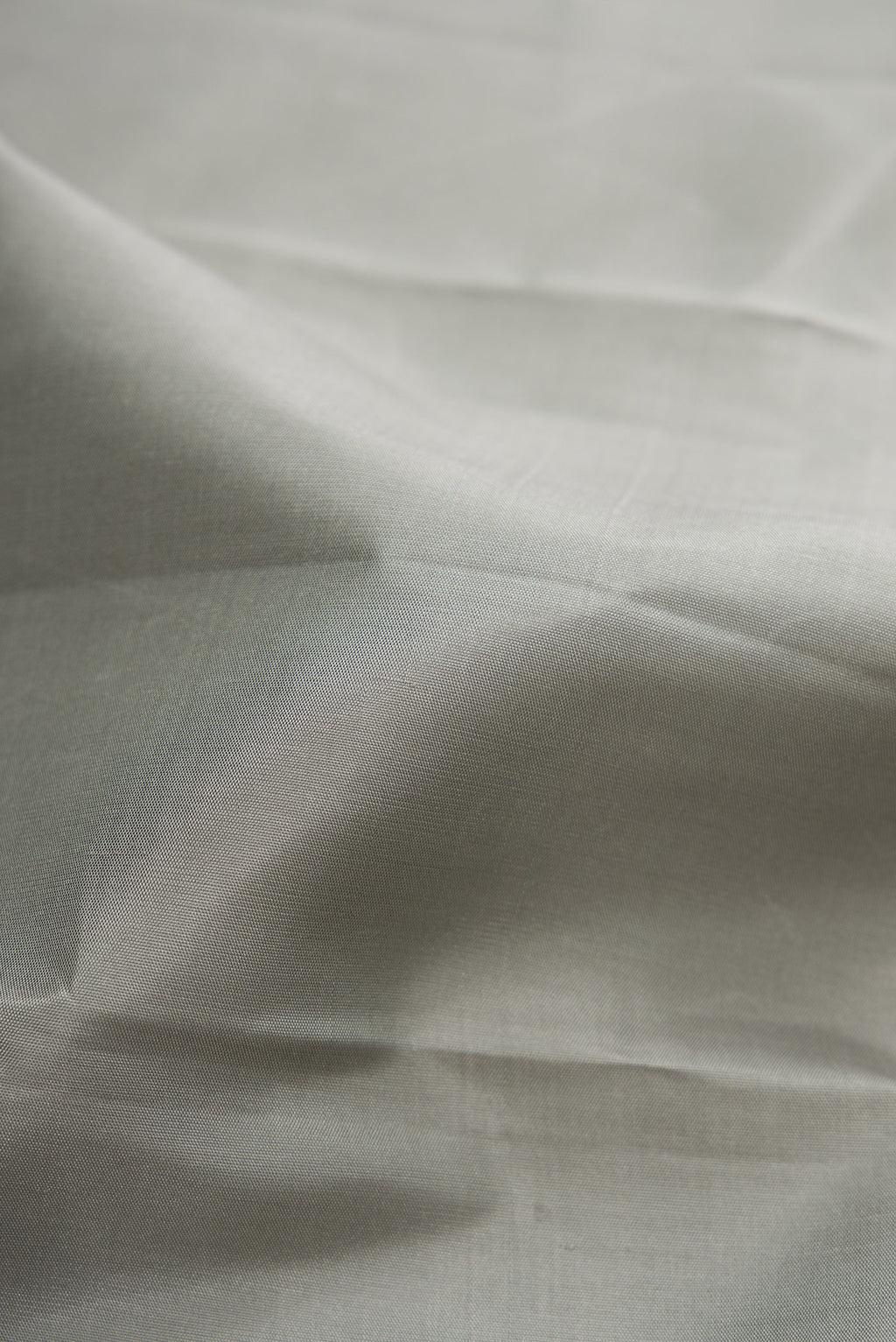 Close up of Pure Silk Pure Zari Grey Dual Tone Kanchipuram Saree with Plain Body and Fancy Border.  displaying folds