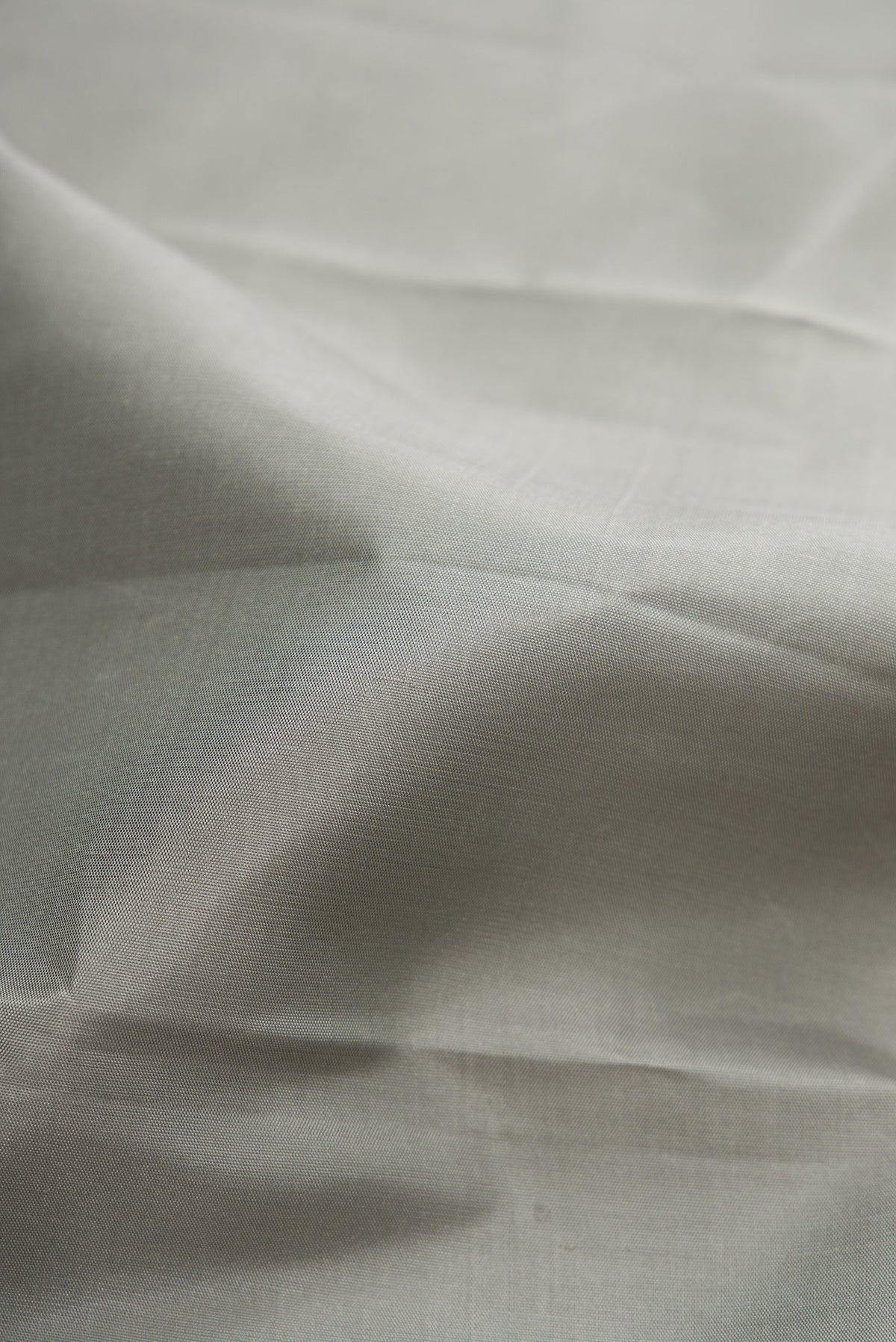 Close up of Pure Silk Pure Zari Grey Dual Tone Kanchipuram Saree with Plain Body and Fancy Border.  displaying folds